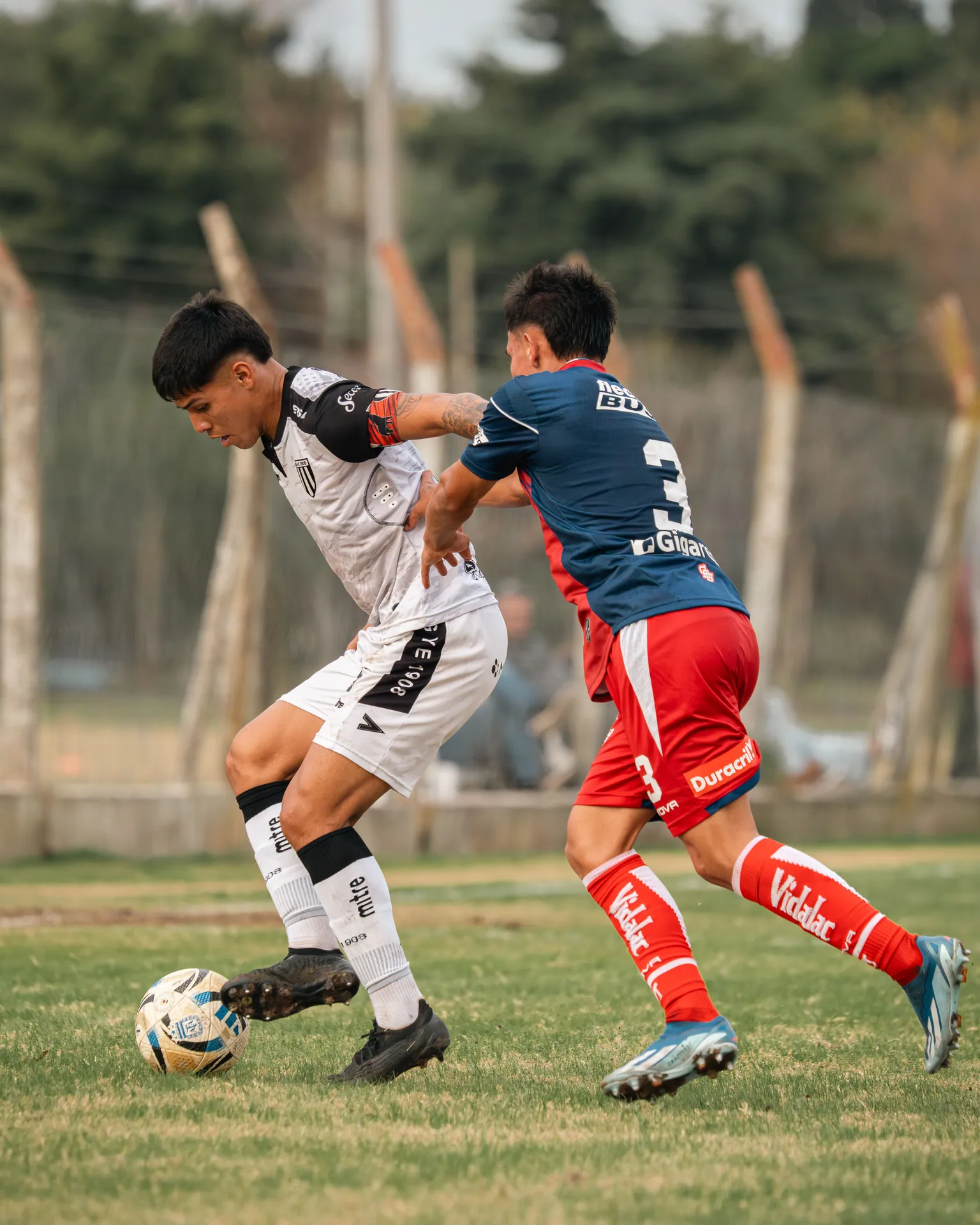 Dynamic soccer match showcasing young athletes in competitive action outdoors.