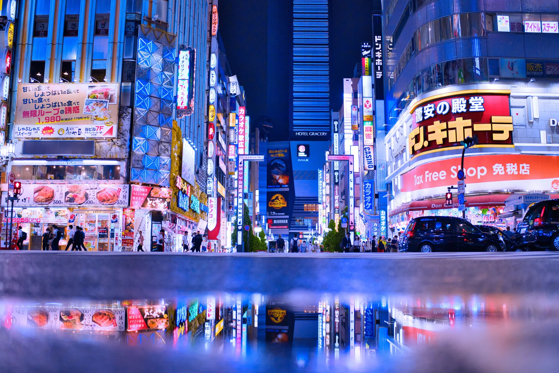 Bright neon lights and bustling activity in Shinjuku, Tokyo at night.