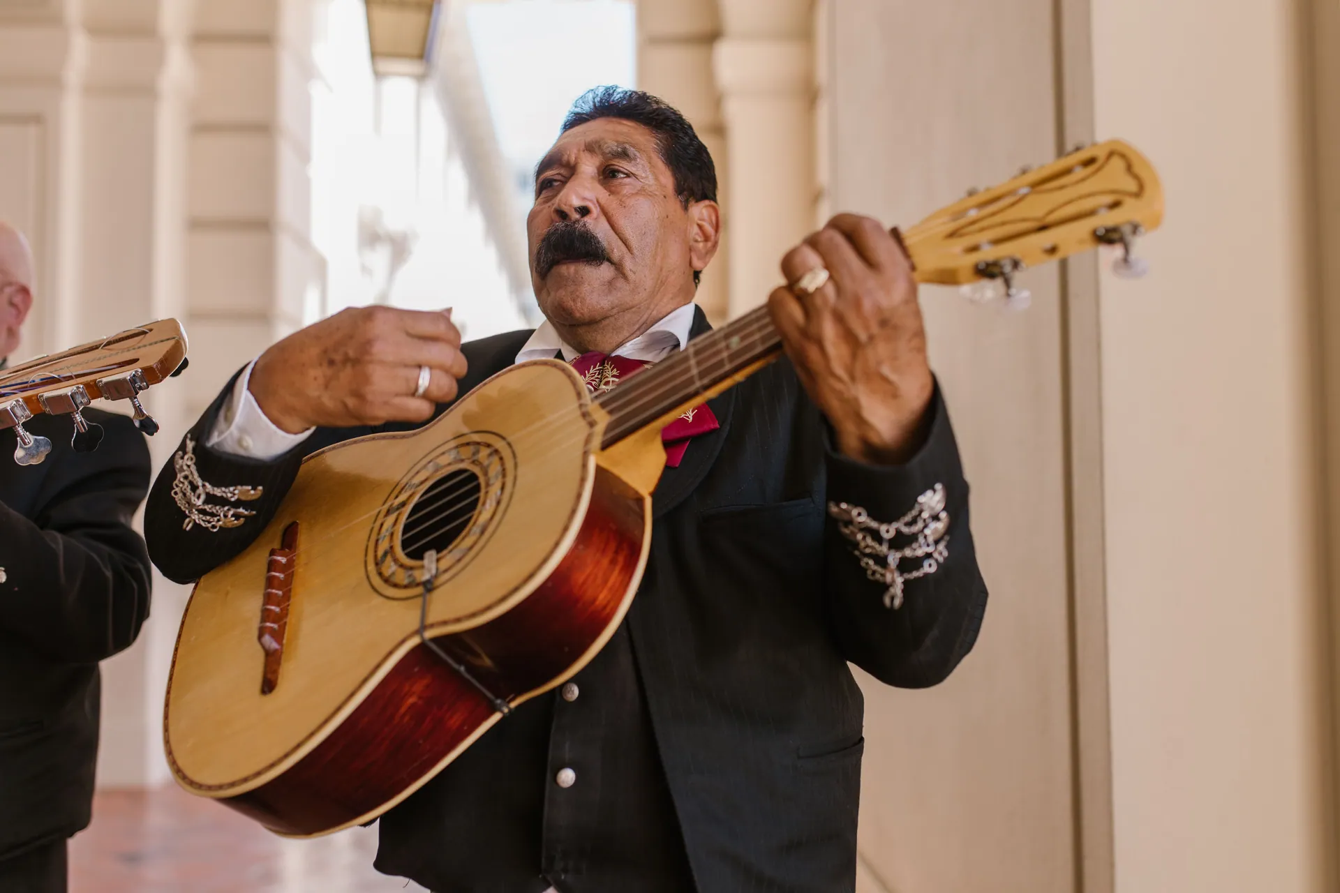 A mariachi musician playing guitar at a fiesta, highlighting cultural music traditions.