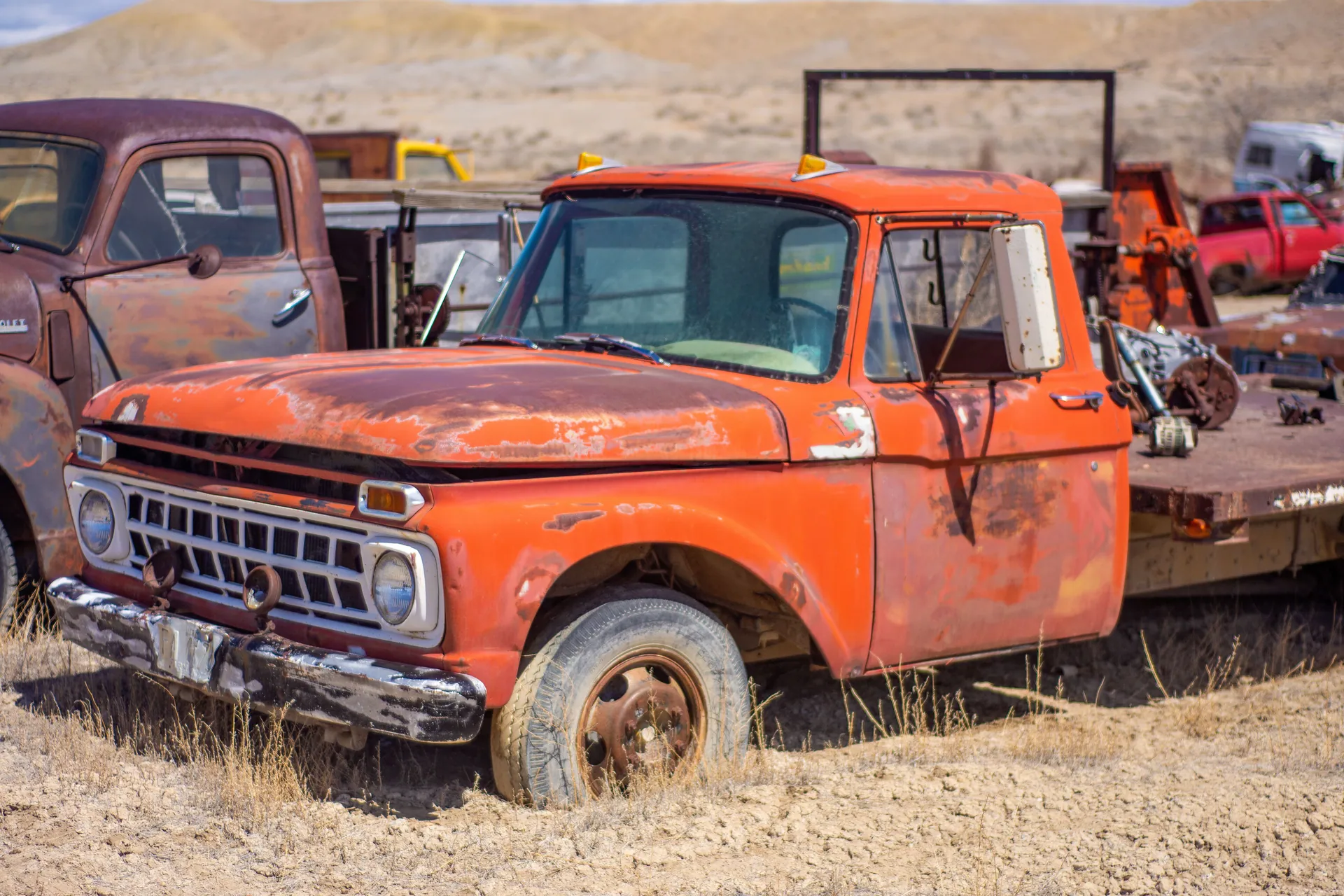 Explore a rusty vintage truck in a desolate junkyard under a sunny sky. Perfect for retro enthusiasts.