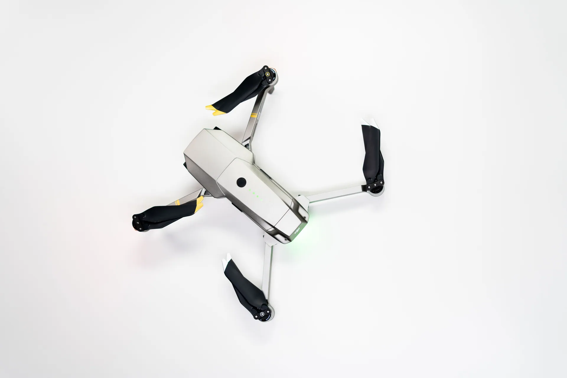 Overhead shot of a quadcopter drone with folded propellers on a clean white background.
