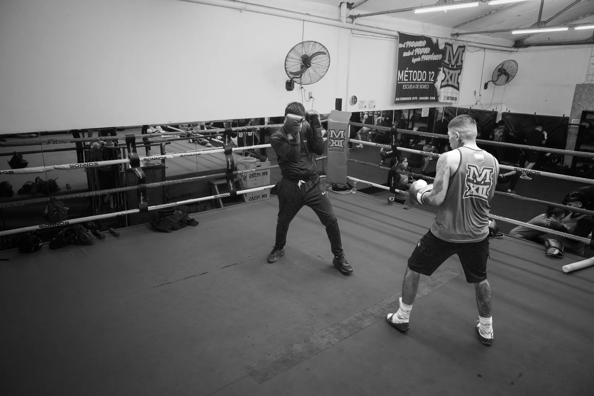 Black and white image of two men practicing boxing in an indoor gym in Argentina.
