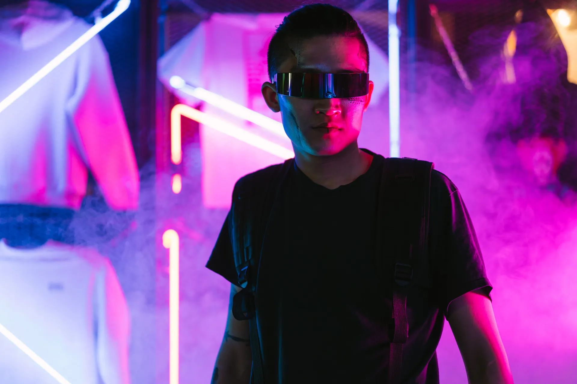 Futuristic man in neon-lit environment wearing sunglasses, exuding cyberpunk style.
