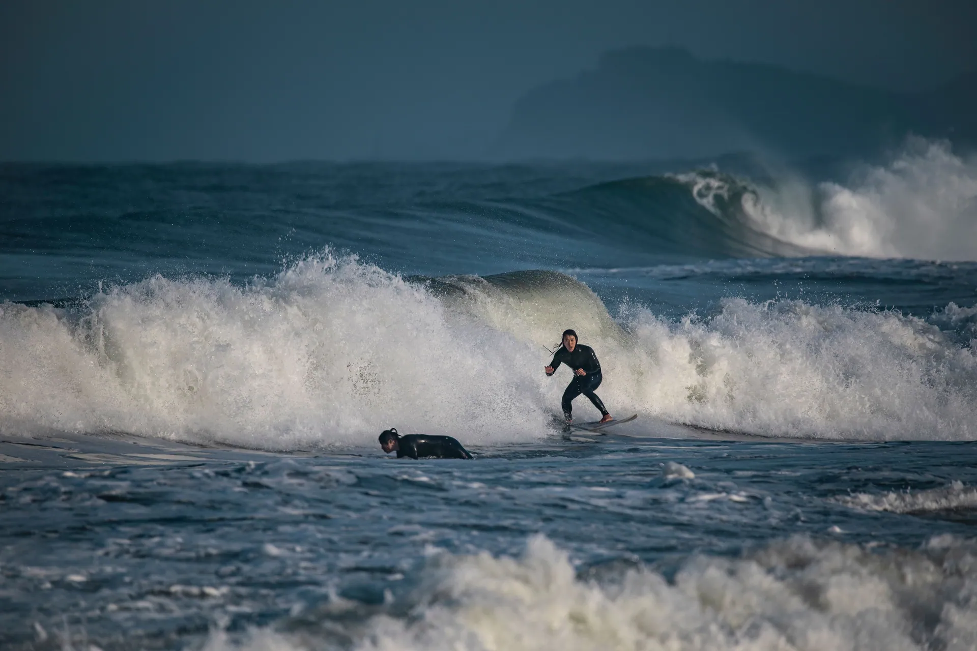 Surfers riding the powerful waves at Yangyang Beach, showcasing the thrill of water sports.