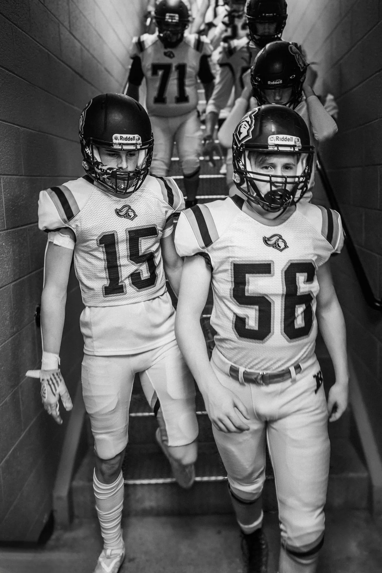 Black and white image of high school football players geared up for the game.