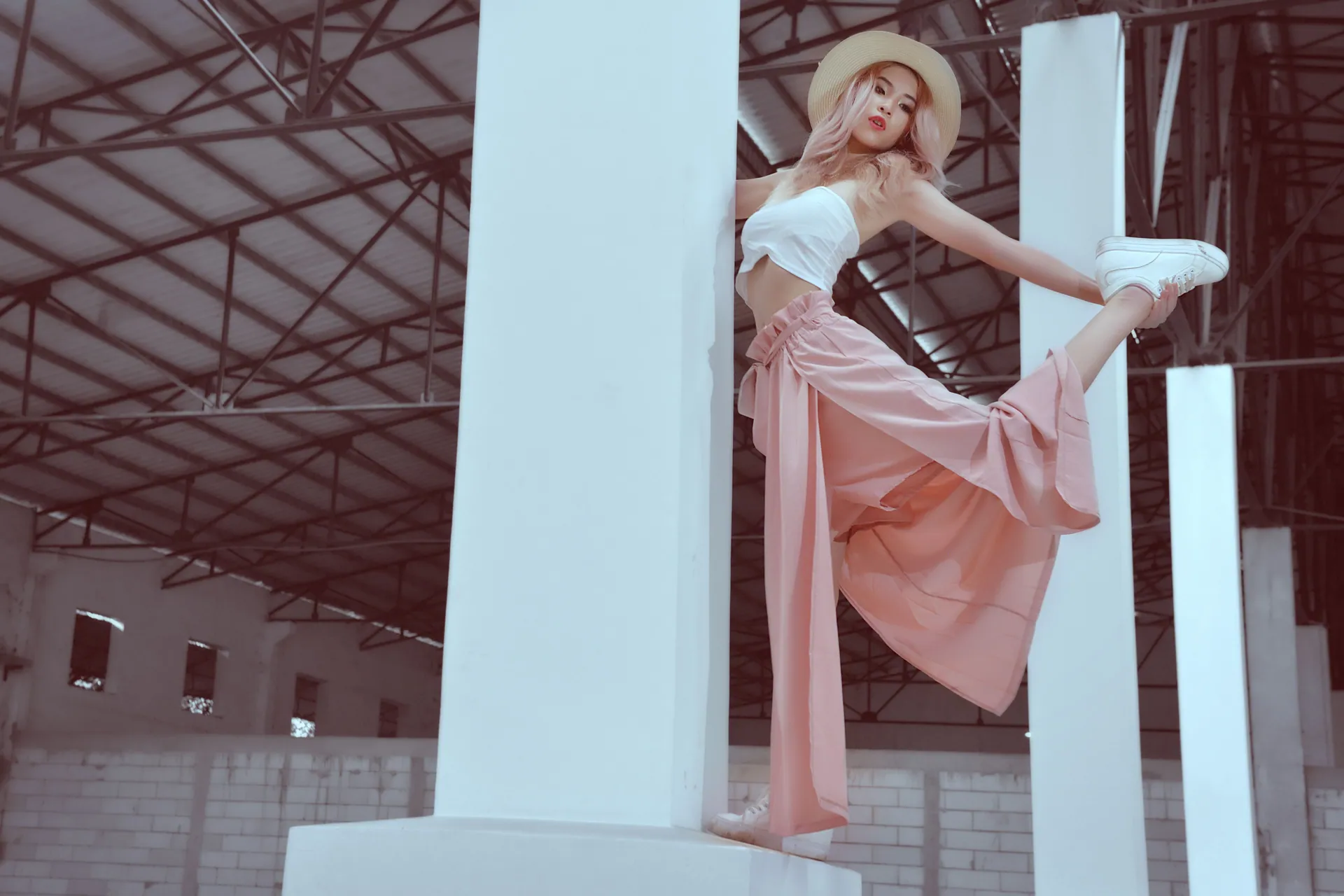 Fashionable woman striking a pose indoors in an industrial building, Phnom Penh.