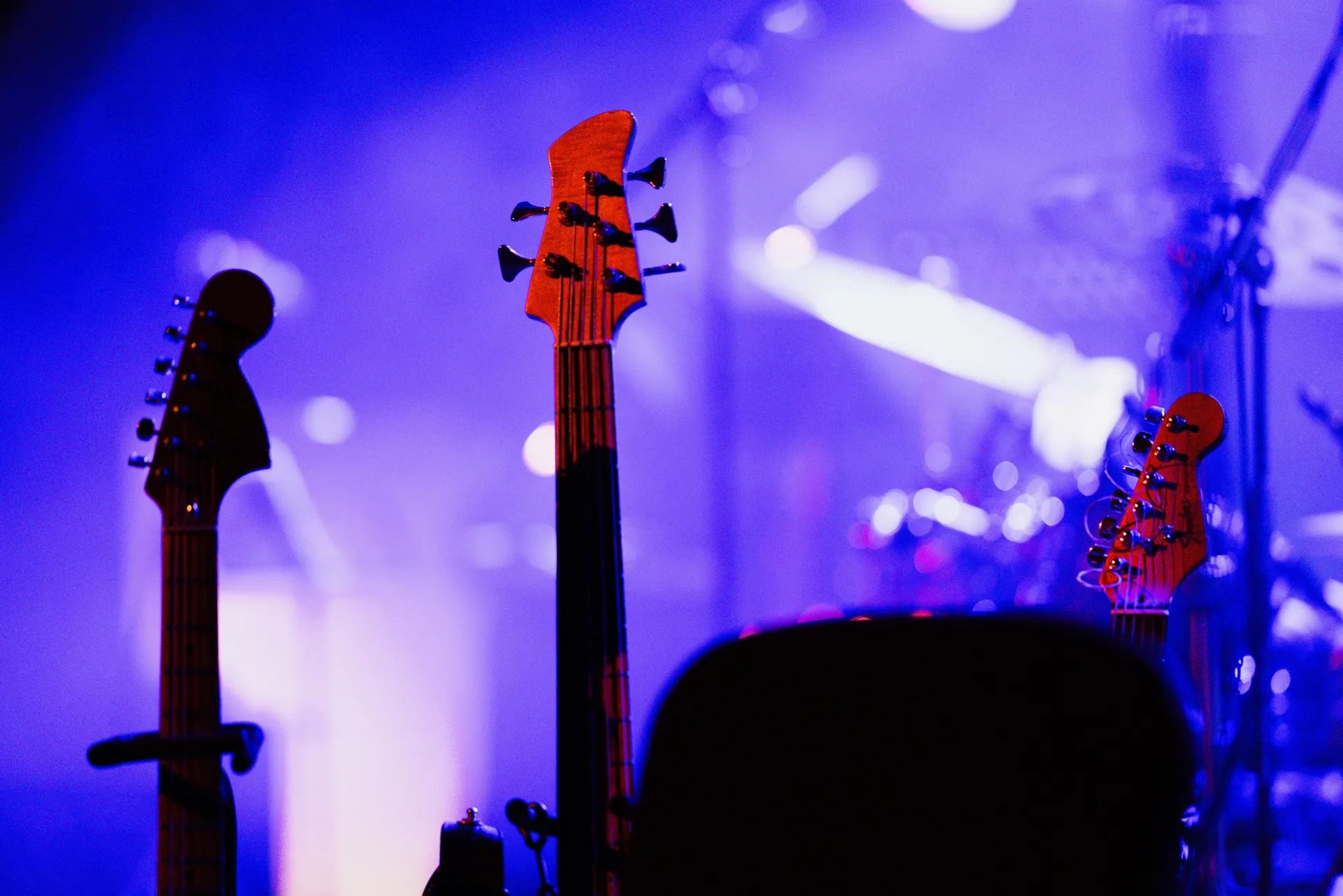 Electric guitars on stage under colorful concert lights, capturing the vibrant music atmosphere.