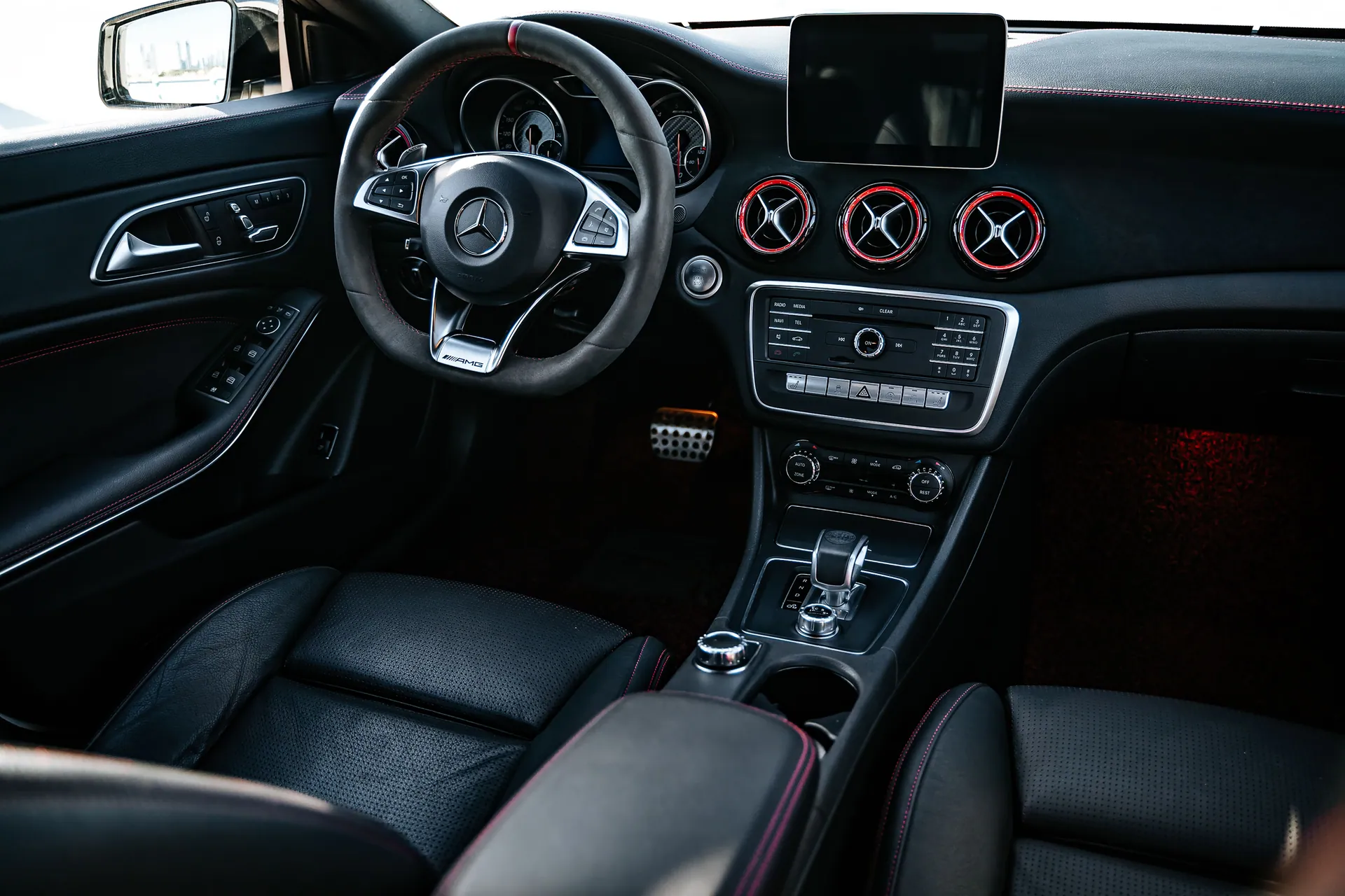 Elegant black car interior showcasing modern dashboard and steering wheel design.