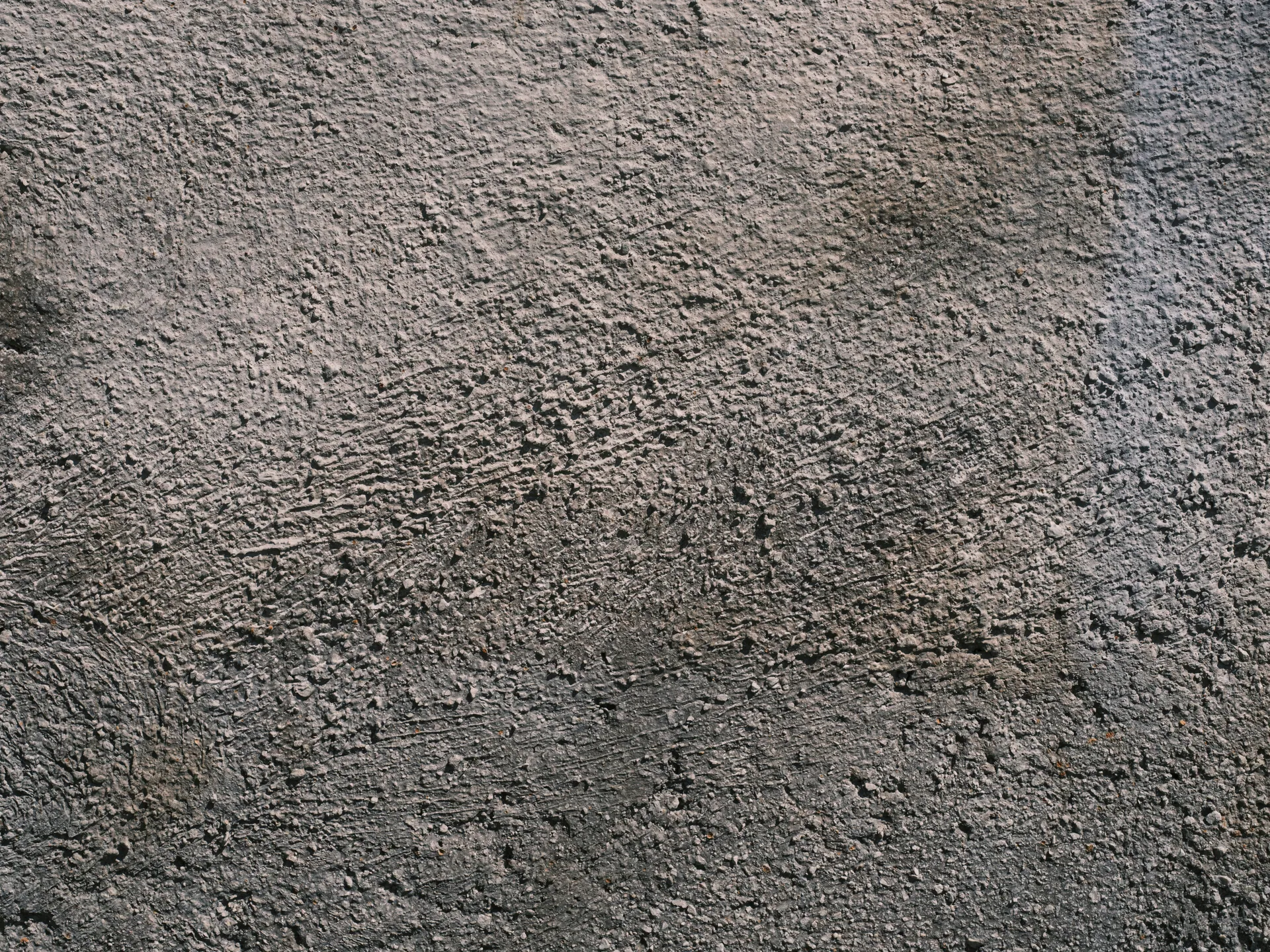 Close-up of a rough textured concrete wall providing a gray solid surface ideal for backgrounds.