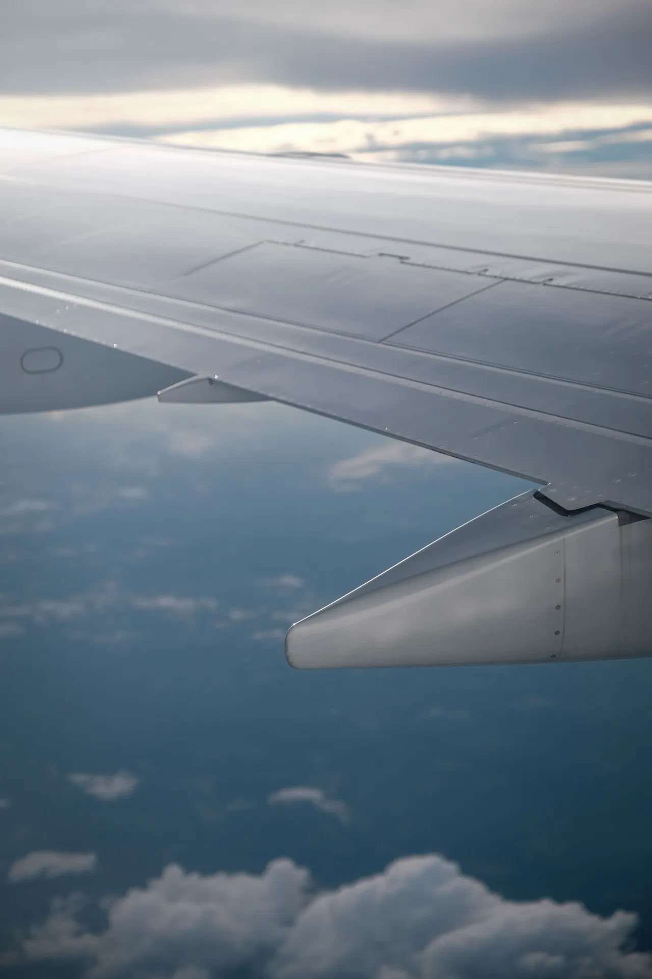 Serene aerial view of airplane wing flying above fluffy clouds in daylight.