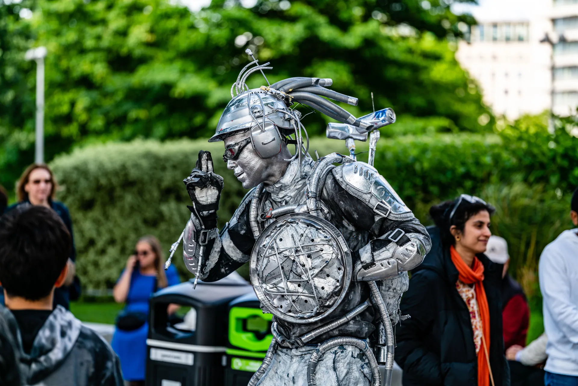 A vibrant street performer in a silver costume entertains tourists in London, creating an energetic urban atmosphere.