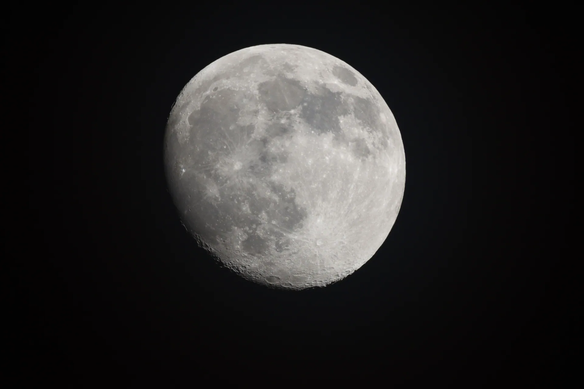 Detailed close-up image of the moon with visible lunar craters and a dark sky background.