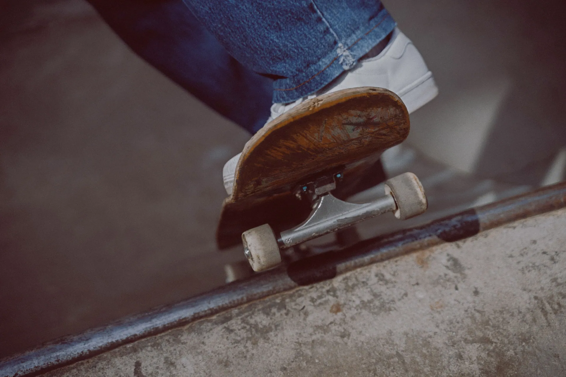 Close-up shot of a skateboarder's foot on a rail, capturing action and movement.