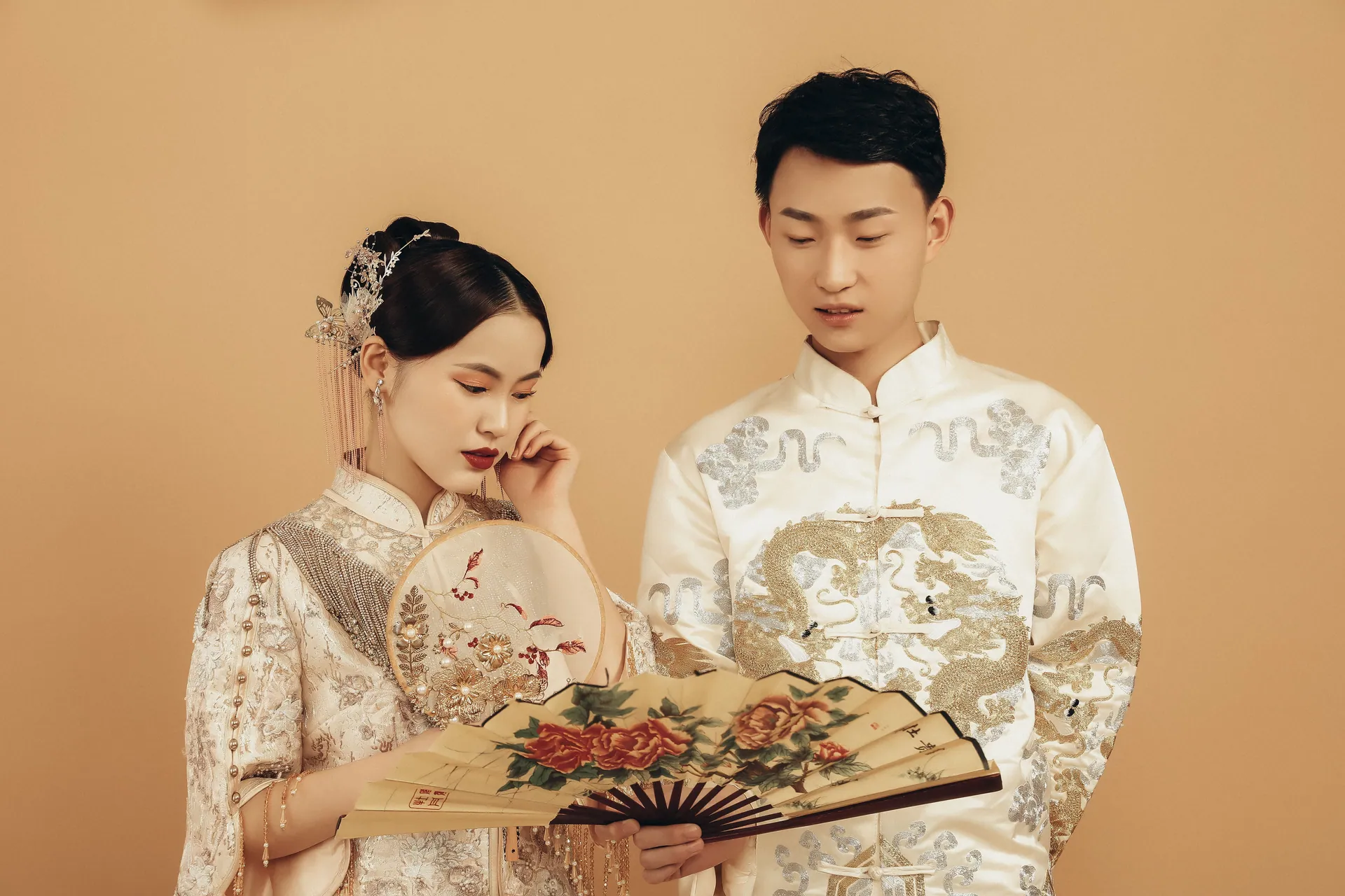 Elegant portrait of a couple in traditional Asian wedding attire, showcasing cultural fashion.