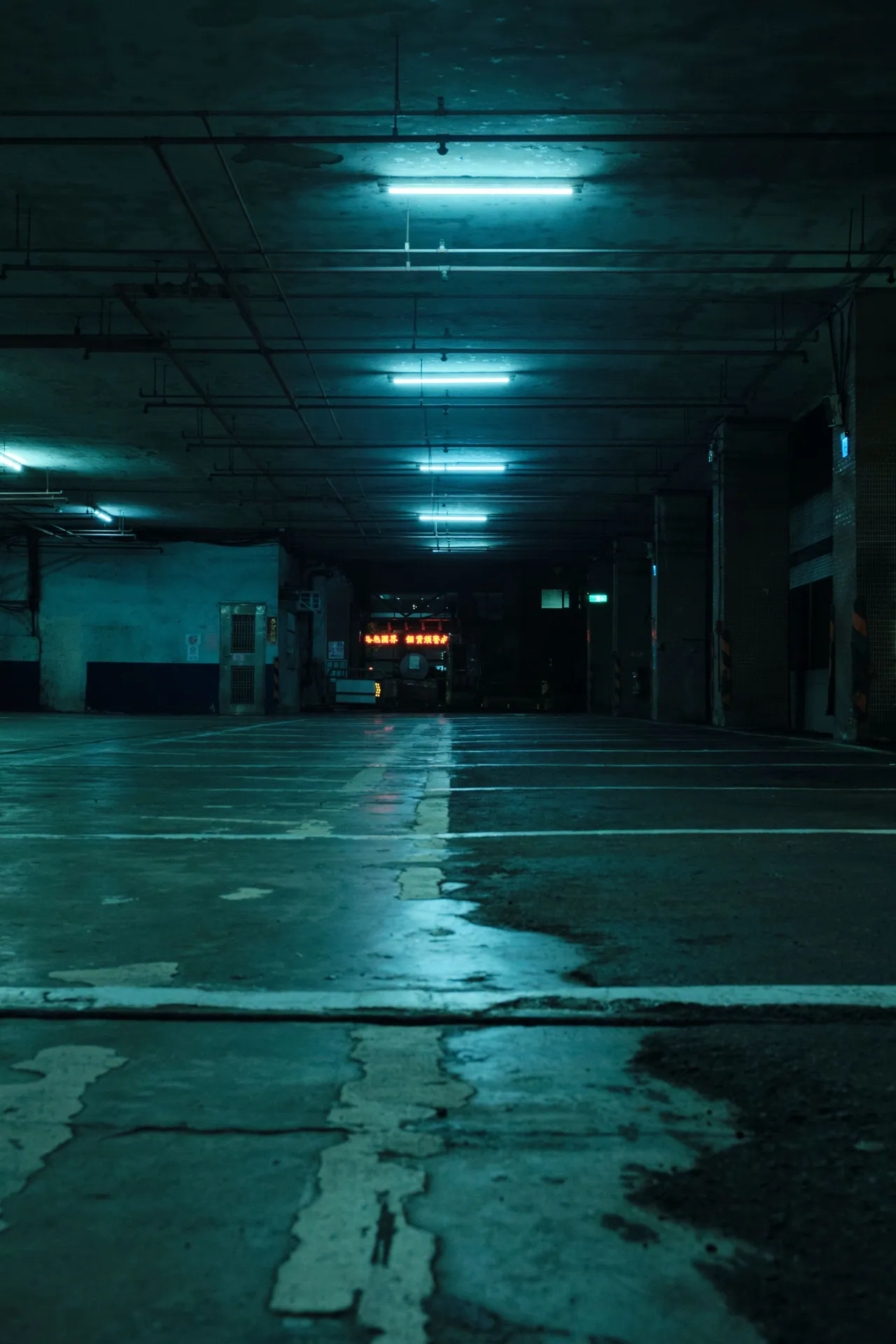 Dark and moody underground parking space in Taipei, showcasing empty and eerie atmosphere.