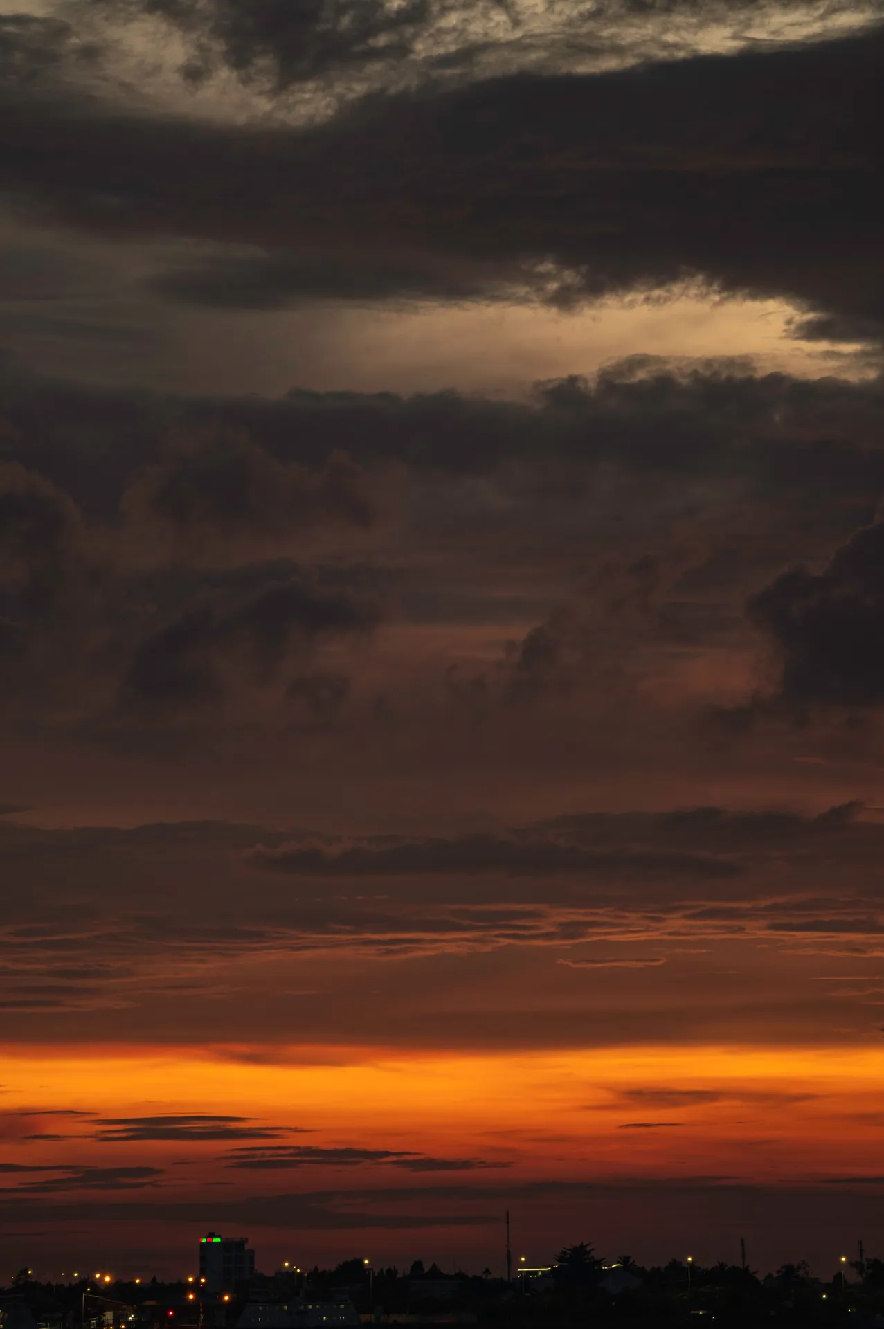 A stunning sunset with rich colors over a tranquil town, perfect for serene landscapes.
