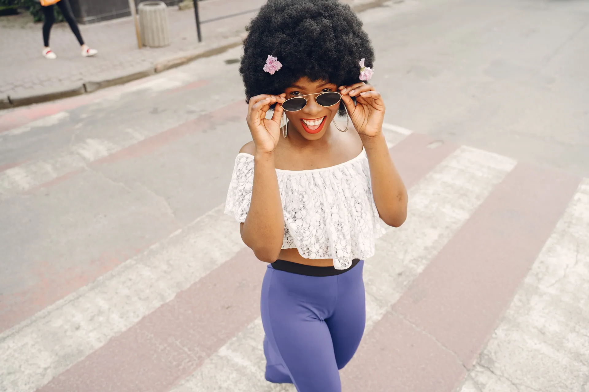 Cheerful woman with afro hair enjoying a sunny day in the city.