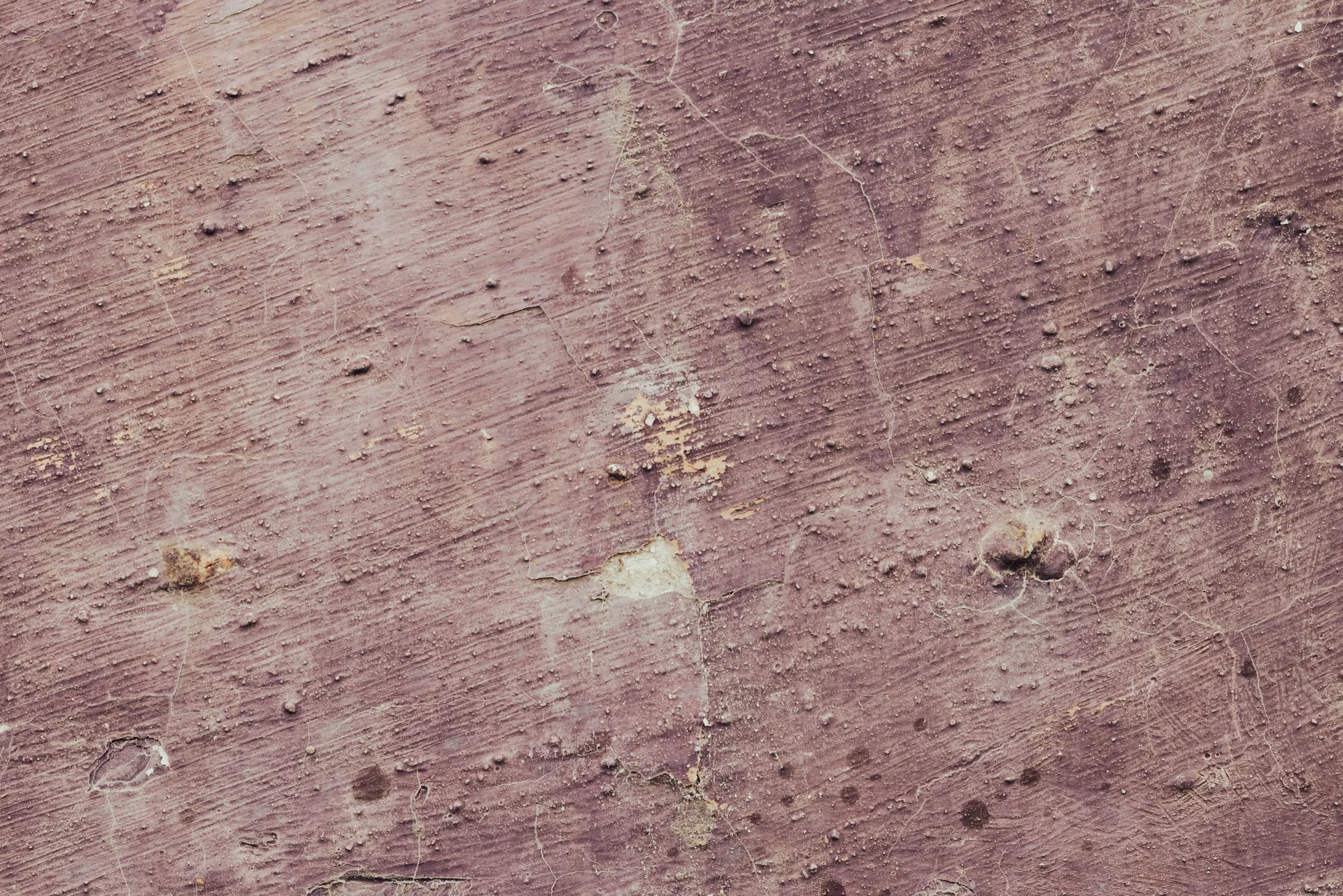Close-up of a textured, aged concrete wall surface with visible signs of weathering.