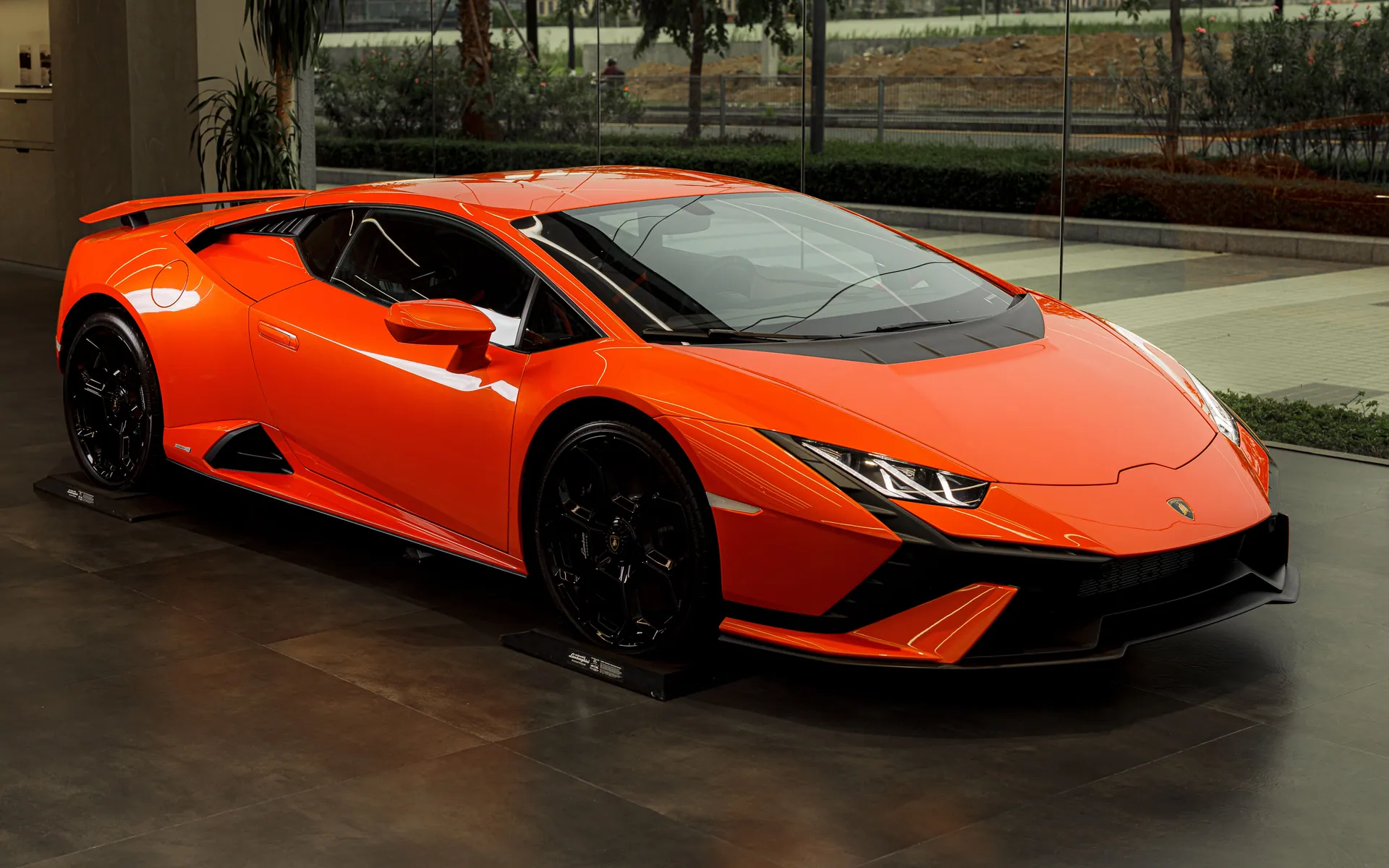 Stunning orange Lamborghini Huracan sports car displayed indoors, showcasing luxury and style.