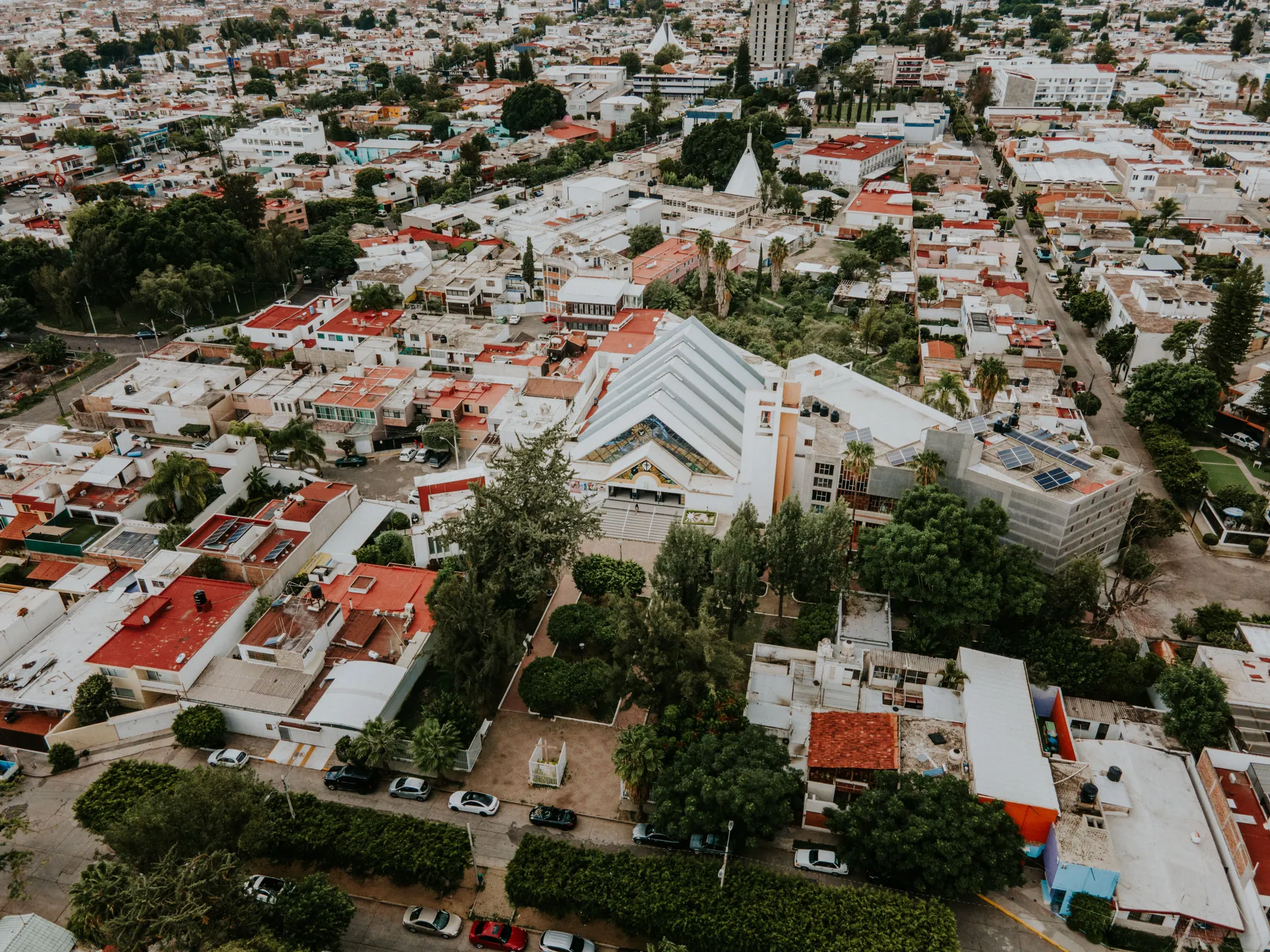 Aerial imagery showcasing a vibrant cityscape with colorful roofs and lush greenery.