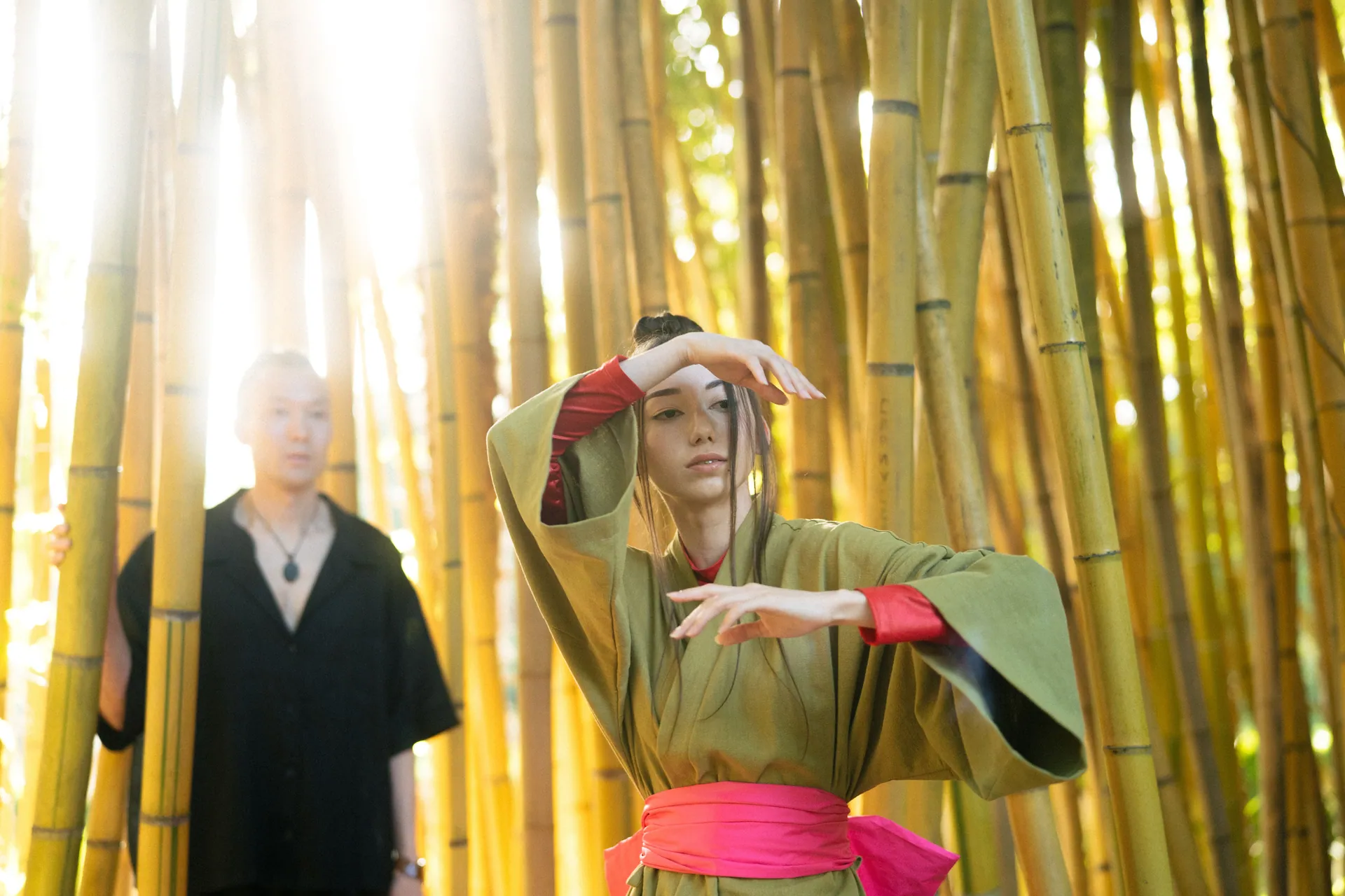 A graceful dancer performs in traditional attire among towering bamboos, capturing peace and beauty.