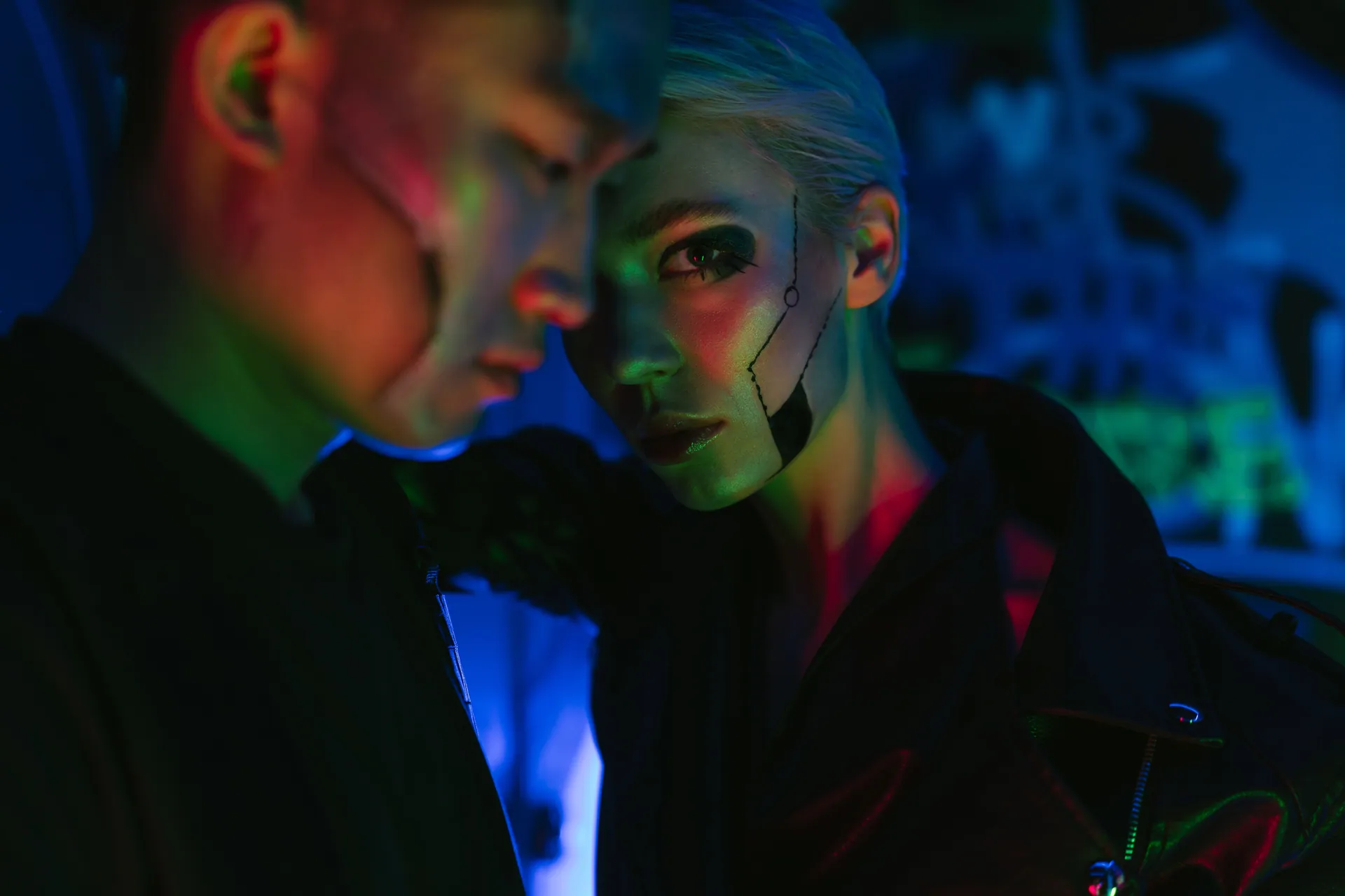 Futuristic cyberpunk scene featuring two people with dramatic neon lighting.