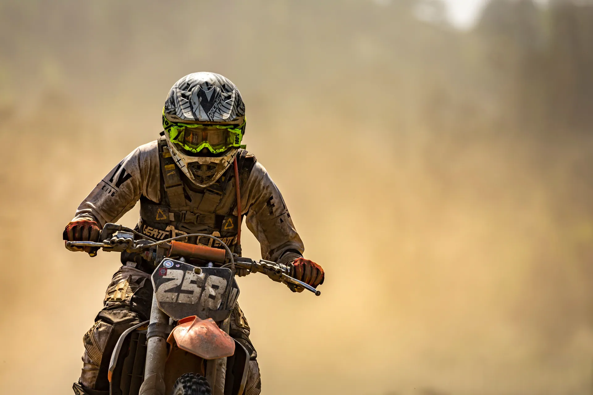 Dirt bike racer speeding through a dusty trail during a thrilling off-road competition.