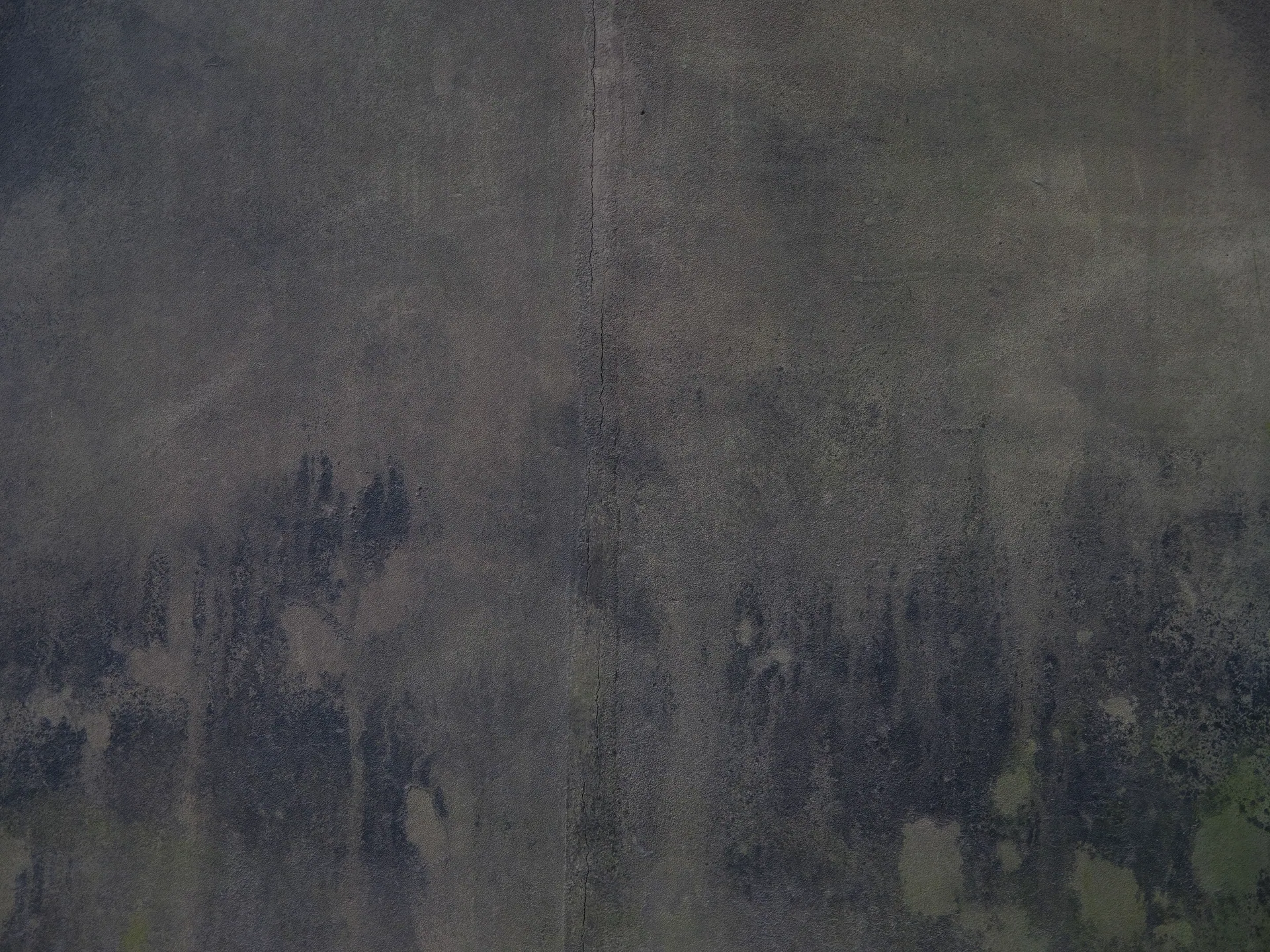 Close-up of a weathered concrete wall with visible textures and patterns.
