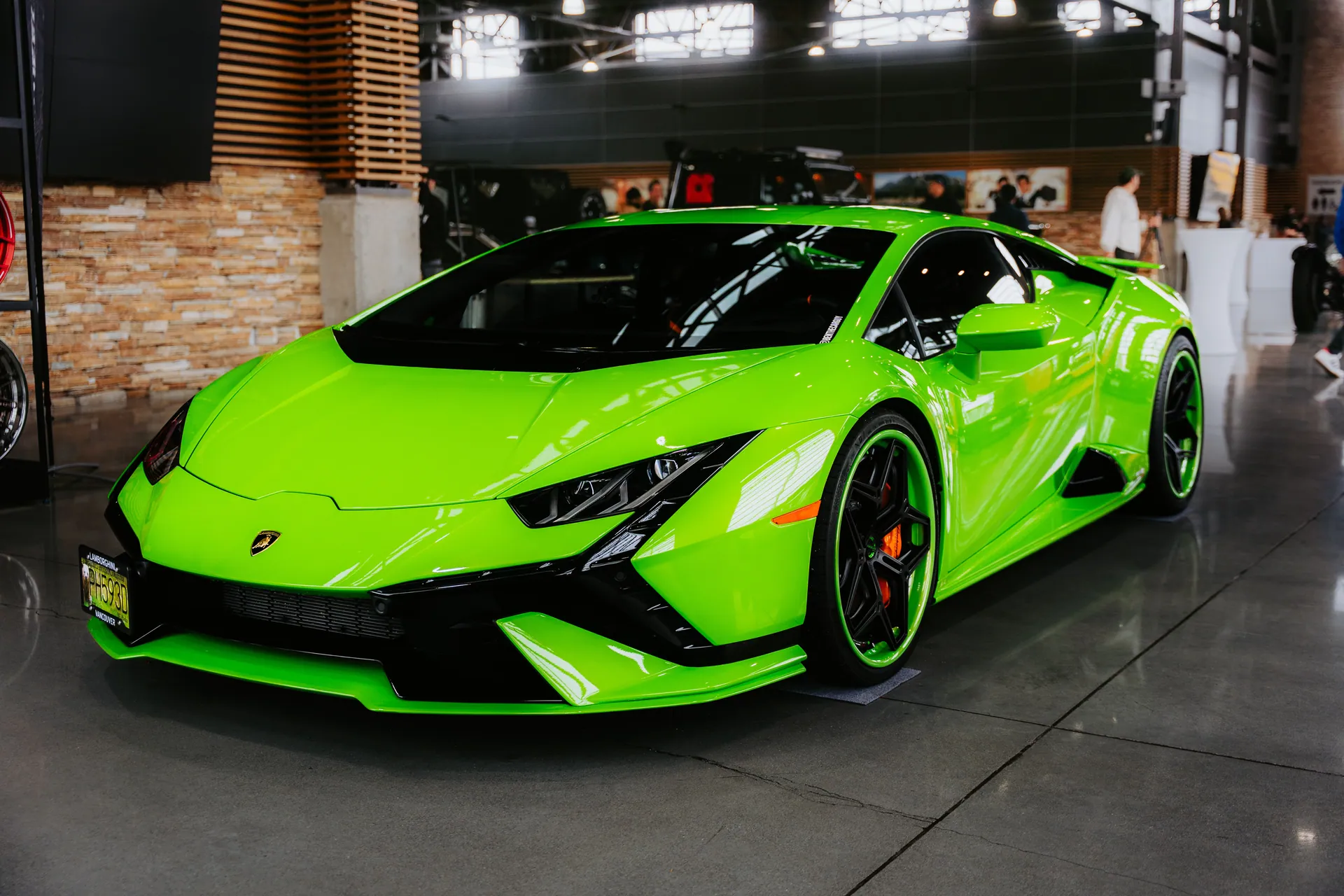 Bright green sports car displayed indoors showcasing modern design and luxury.
