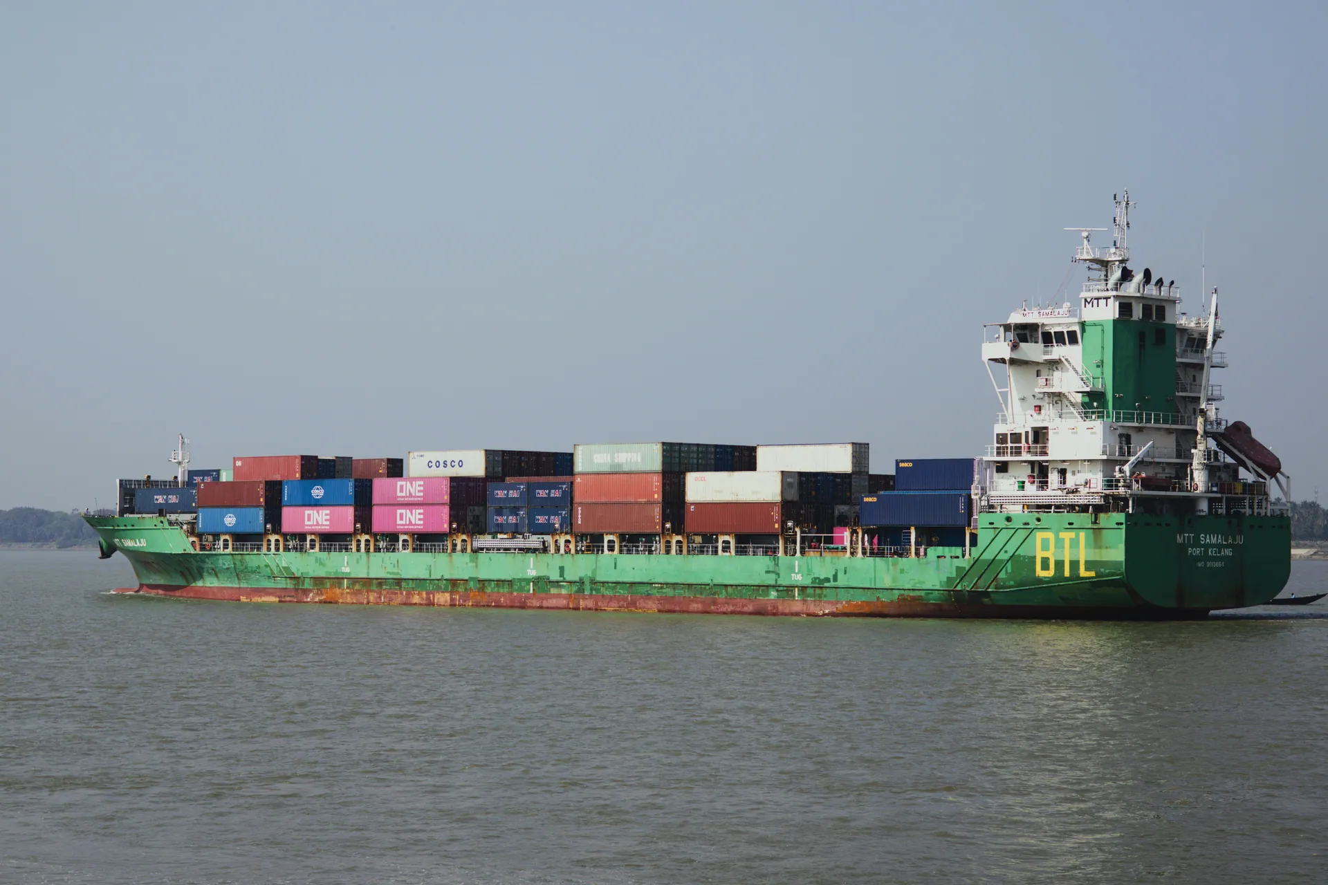 A container ship transporting goods across the ocean under clear skies.