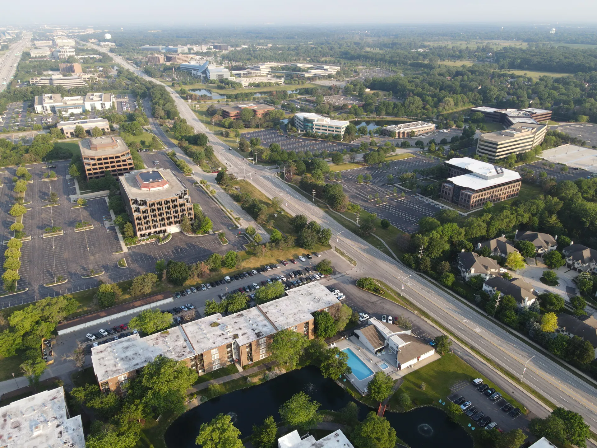 Aerial view showcasing the suburban business district in Lisle, Illinois, highlighting roads, buildings, and greenery.