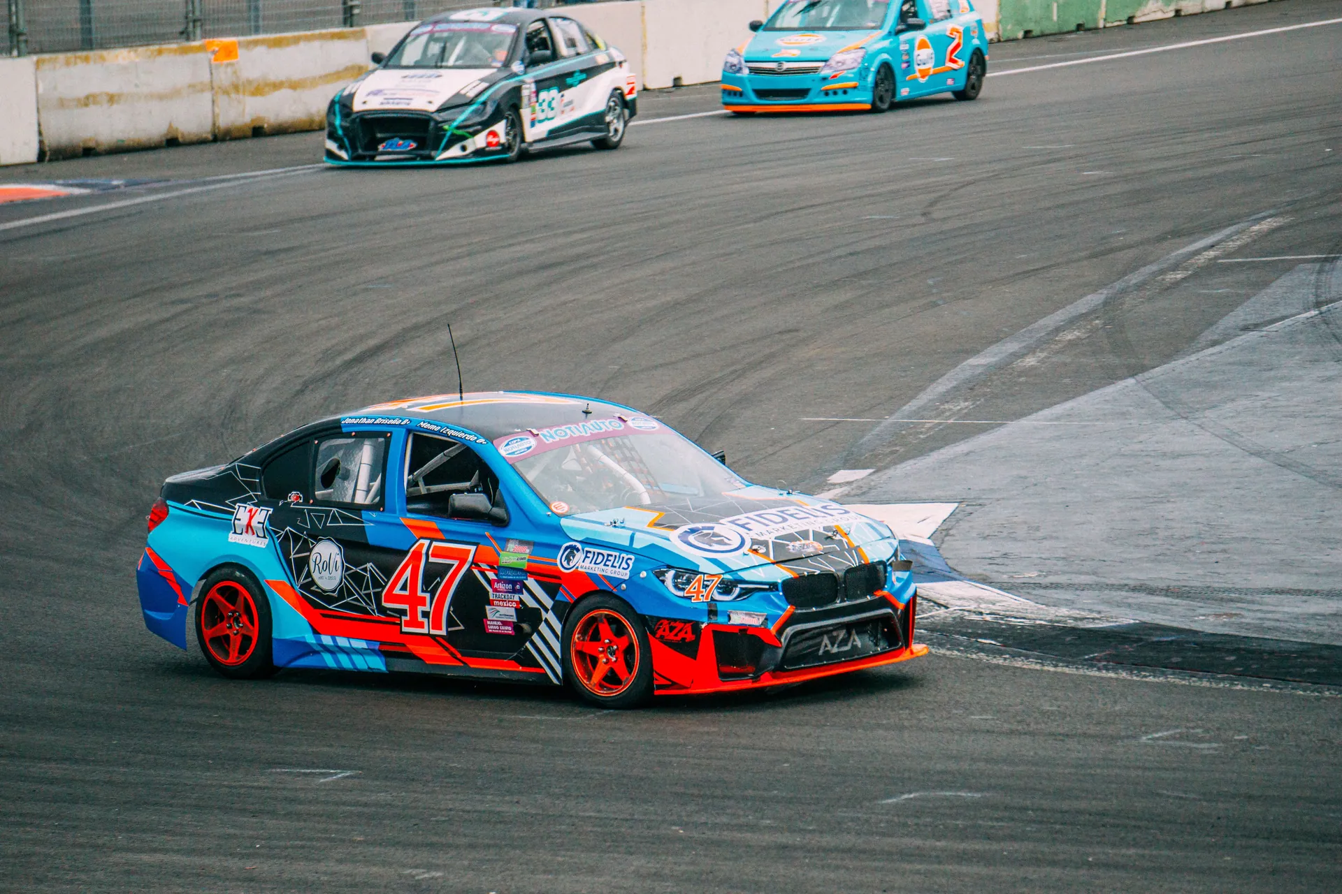 Exciting car racing scene on a professional asphalt track, showcasing speed and competition.