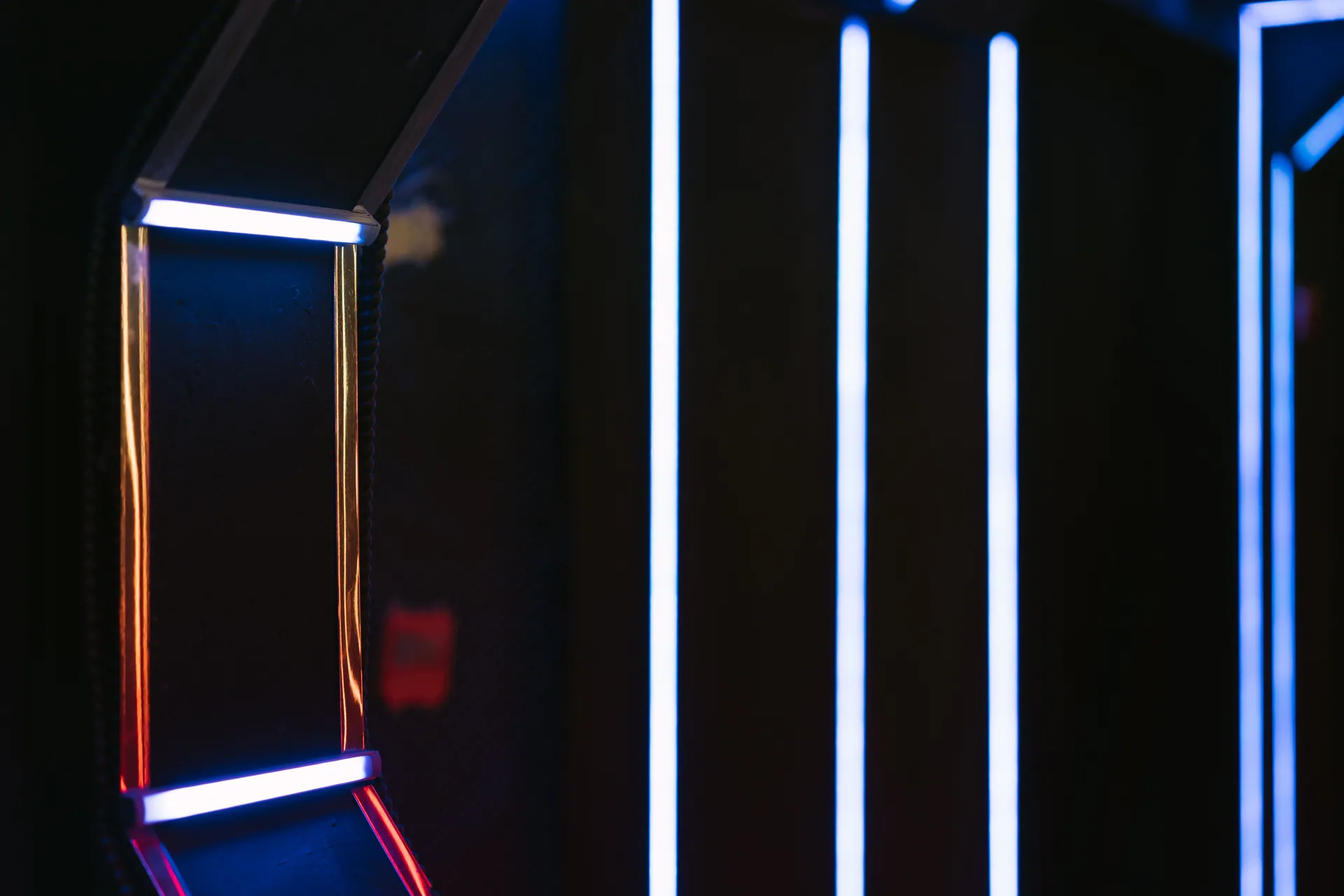 Abstract image featuring illuminated neon lights on a dark wall, creating a futuristic ambiance.