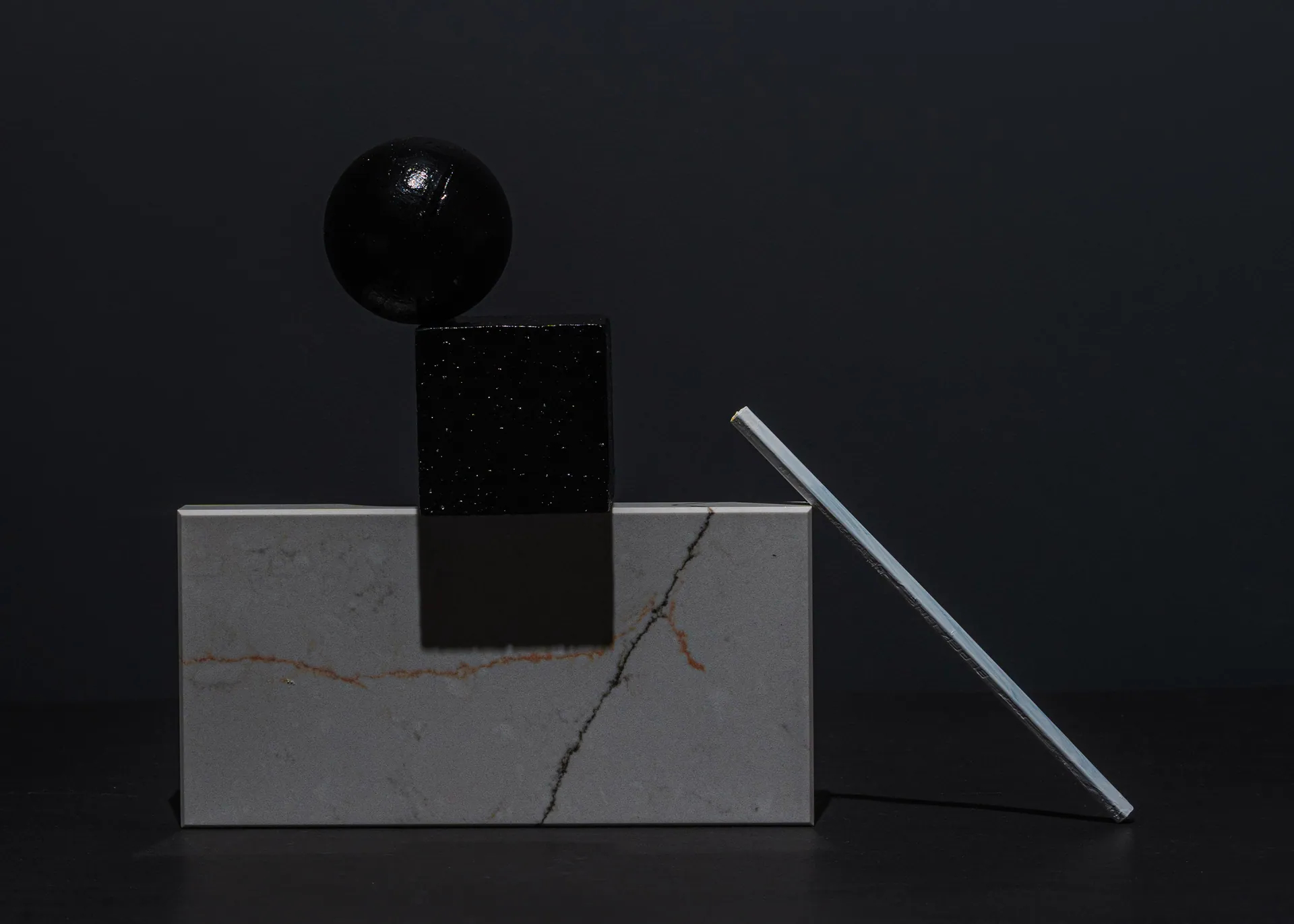 Abstract arrangement of geometric shapes on a dark background showcasing minimalist design.