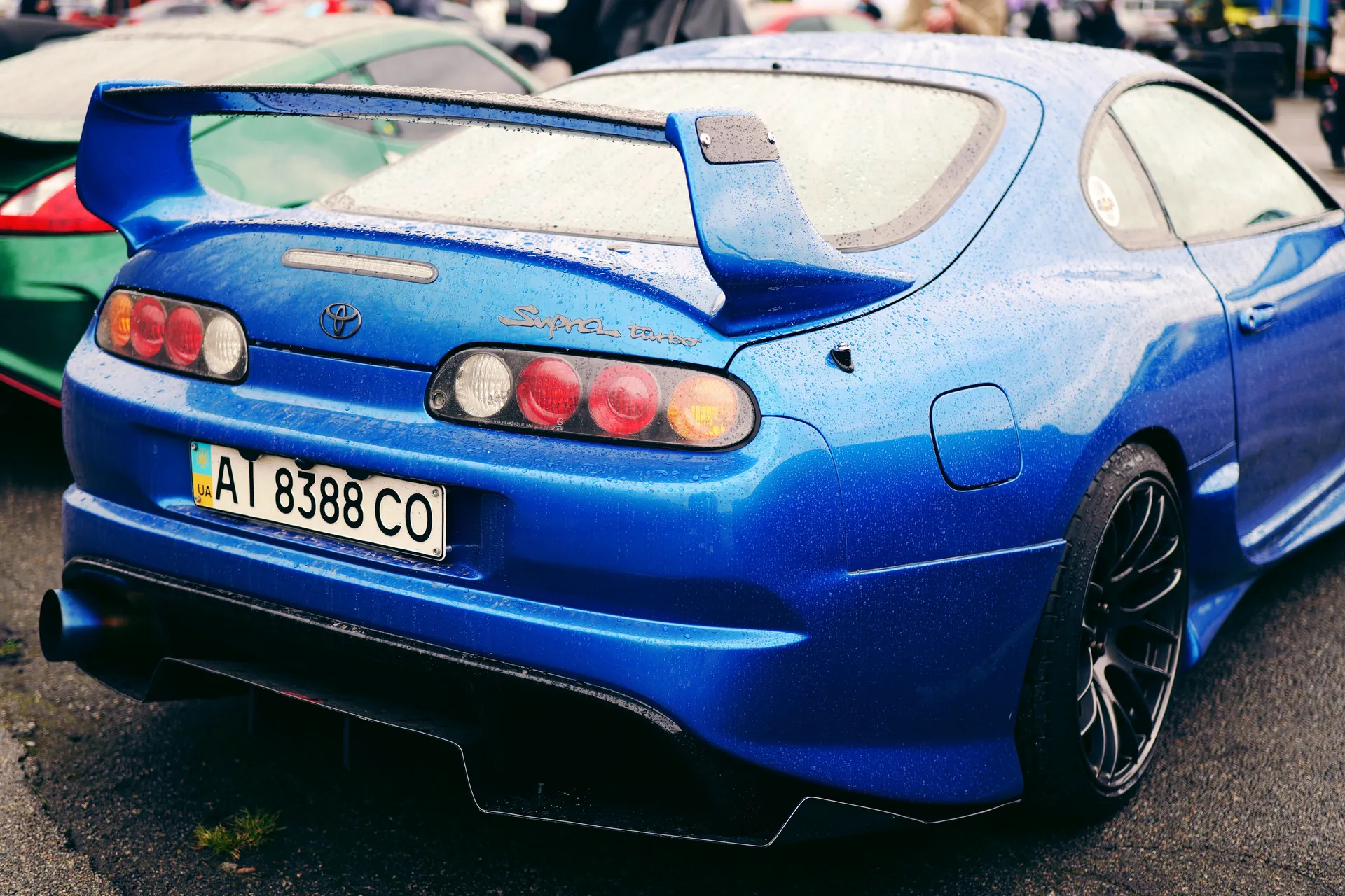 Vibrant blue Toyota Supra showcased at a car event in Ukraine, highlighting its sleek design.