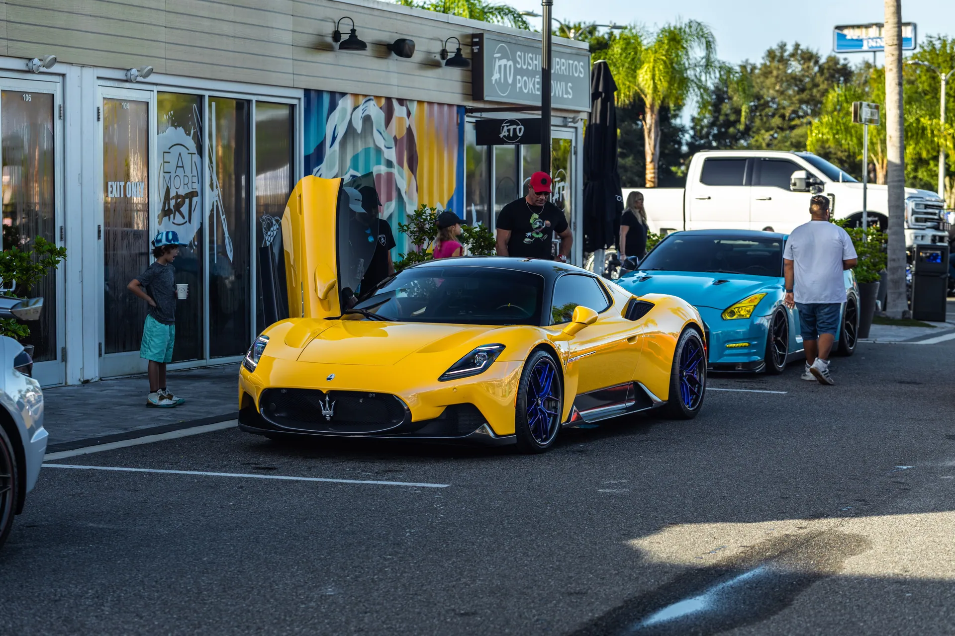 Captivating yellow Maserati MC20 showcased at an outdoor car event under daylight.