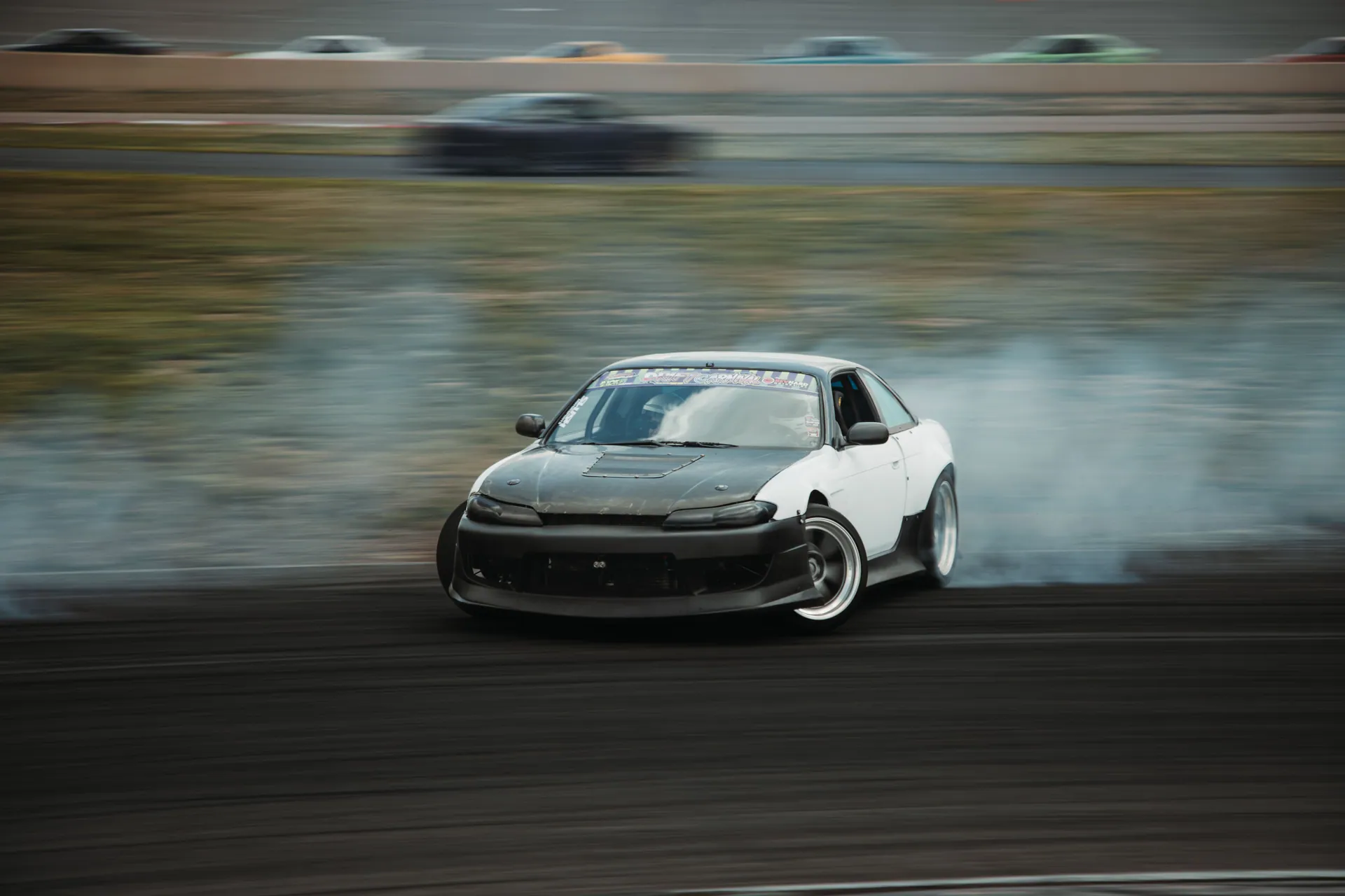 A thrilling shot of a racecar drifting on a track in Colorado, showcasing speed and precision.