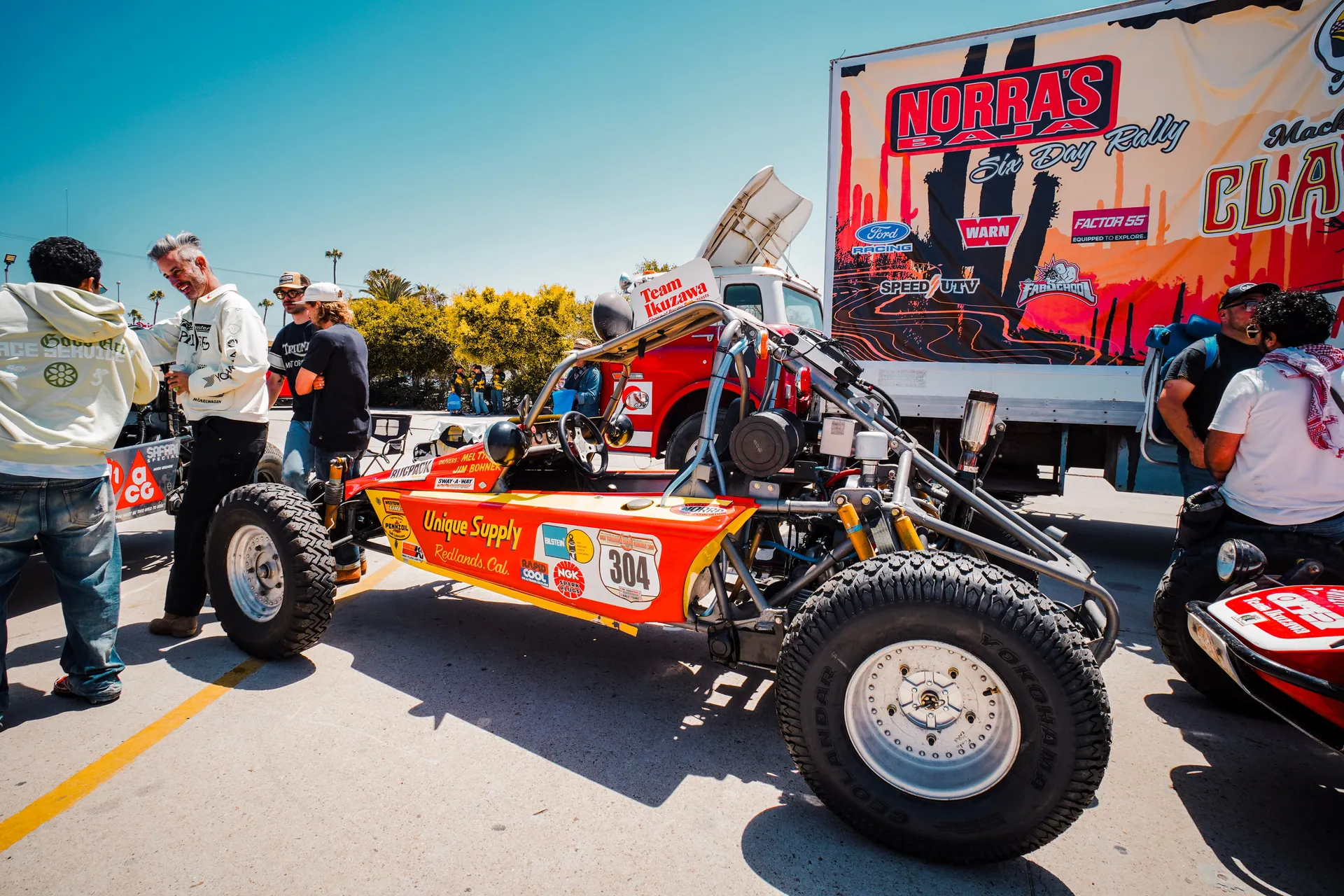 Exciting off-road rally event showcasing colorful buggies and enthusiastic participants under a bright sky.