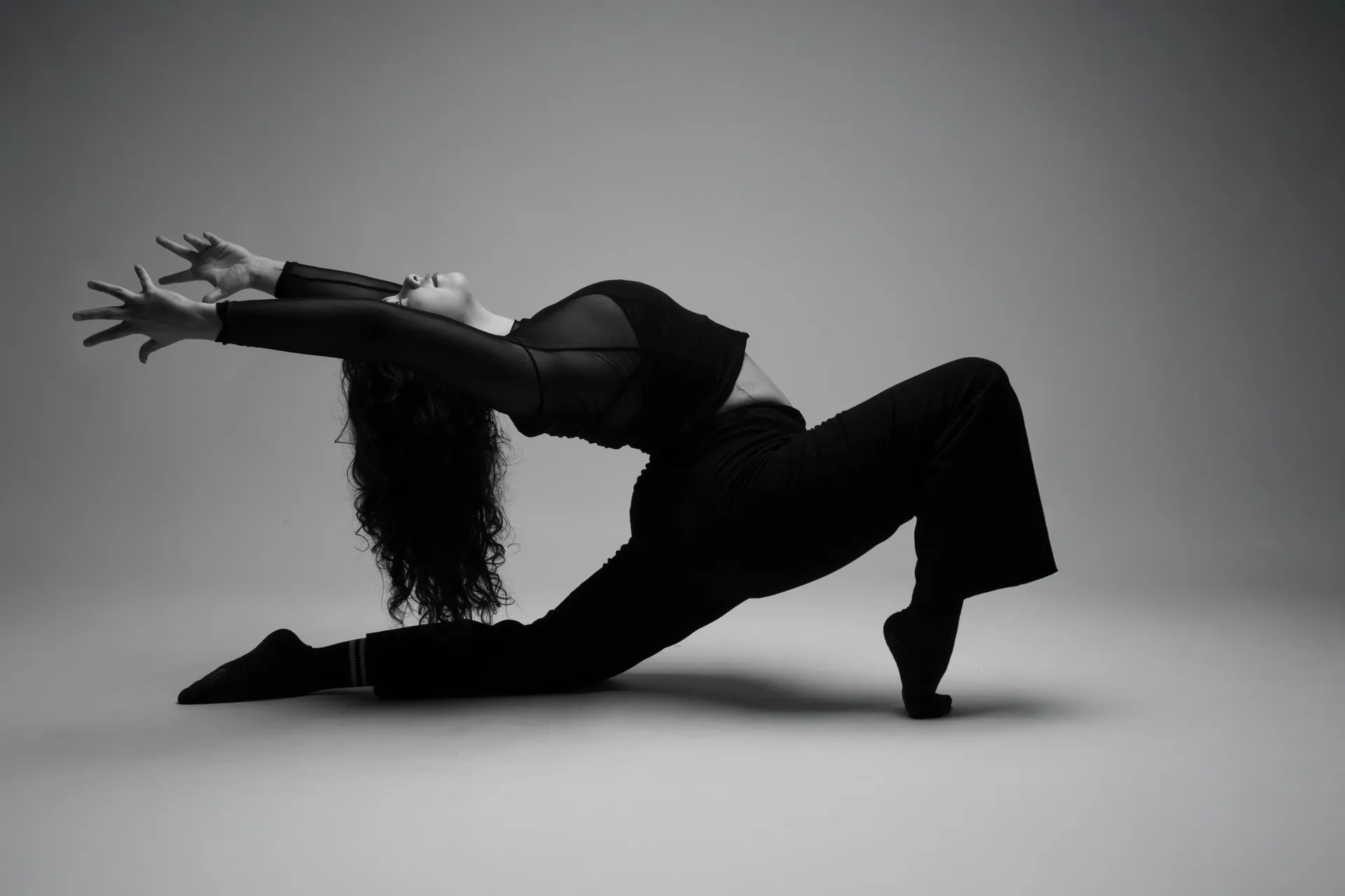 Black and white photo of a dancer posing gracefully in a dramatic stretch.