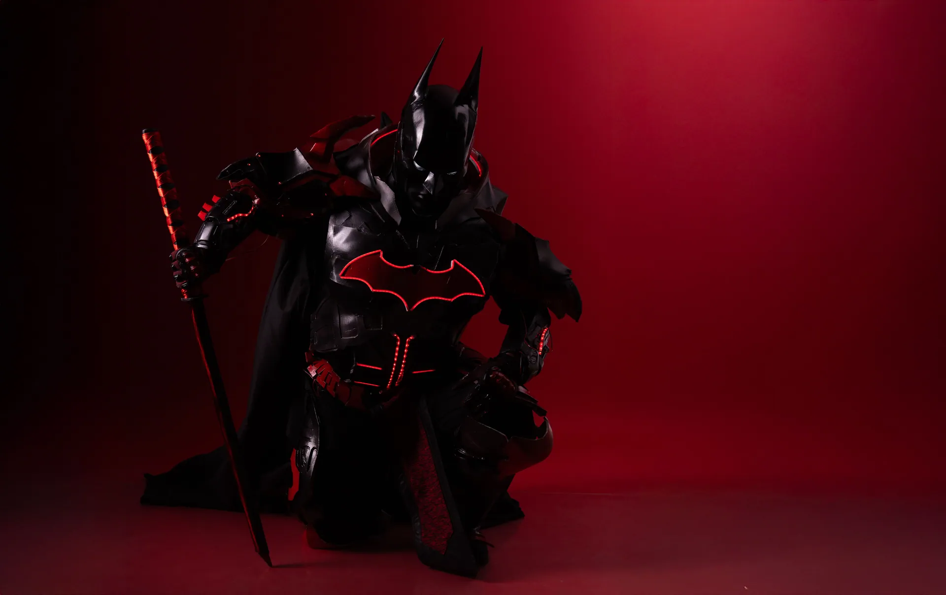 Striking image of Batman cosplay featuring a sword in dramatic red lighting.