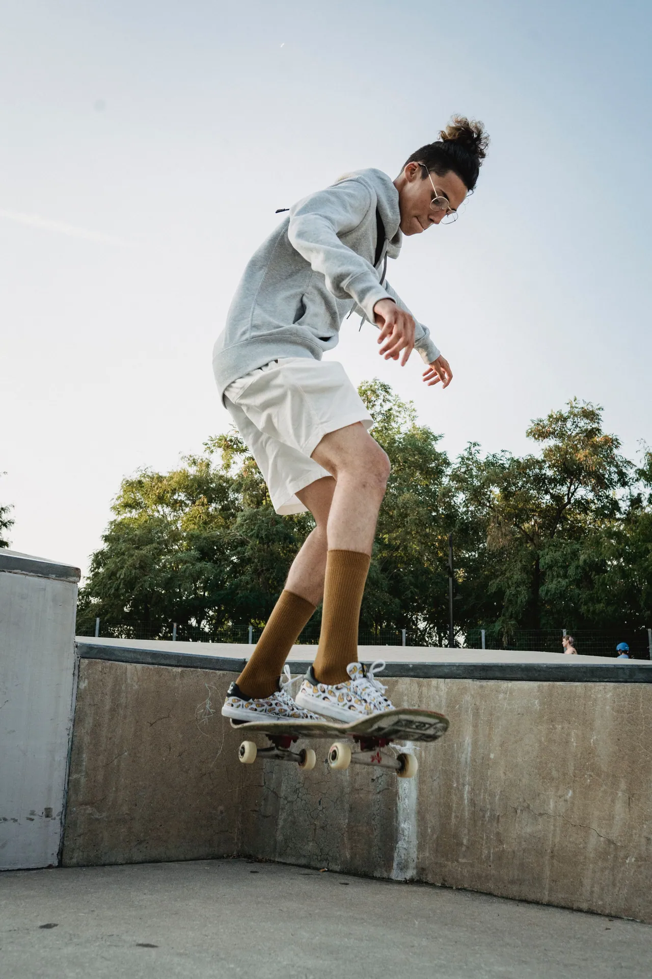 Skateboarder performing a trick in outdoor skate park, showcasing balance and skill.