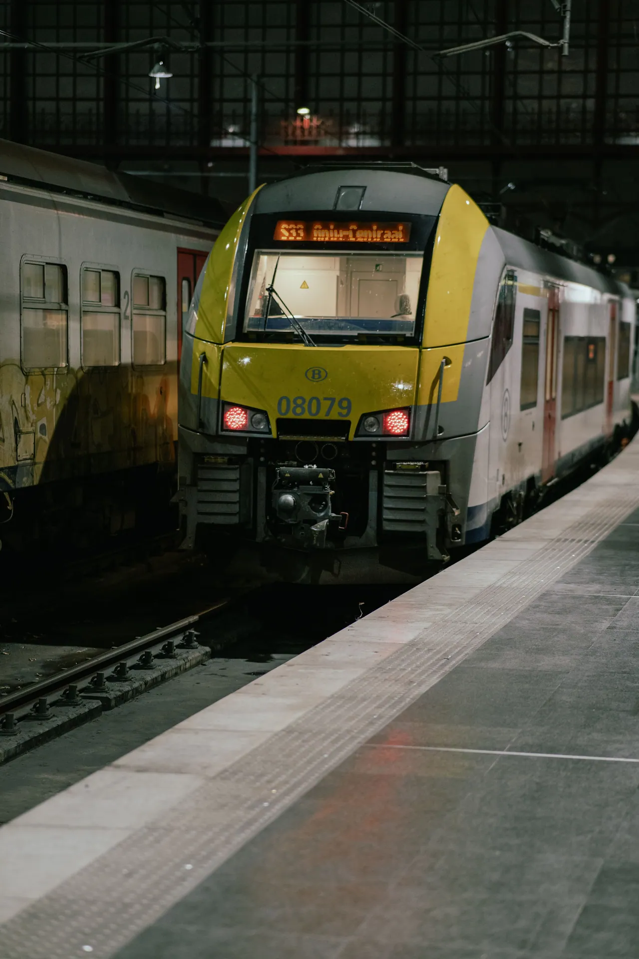 A sleek train at night stationed on a platform in Antwerpen, Belgium.