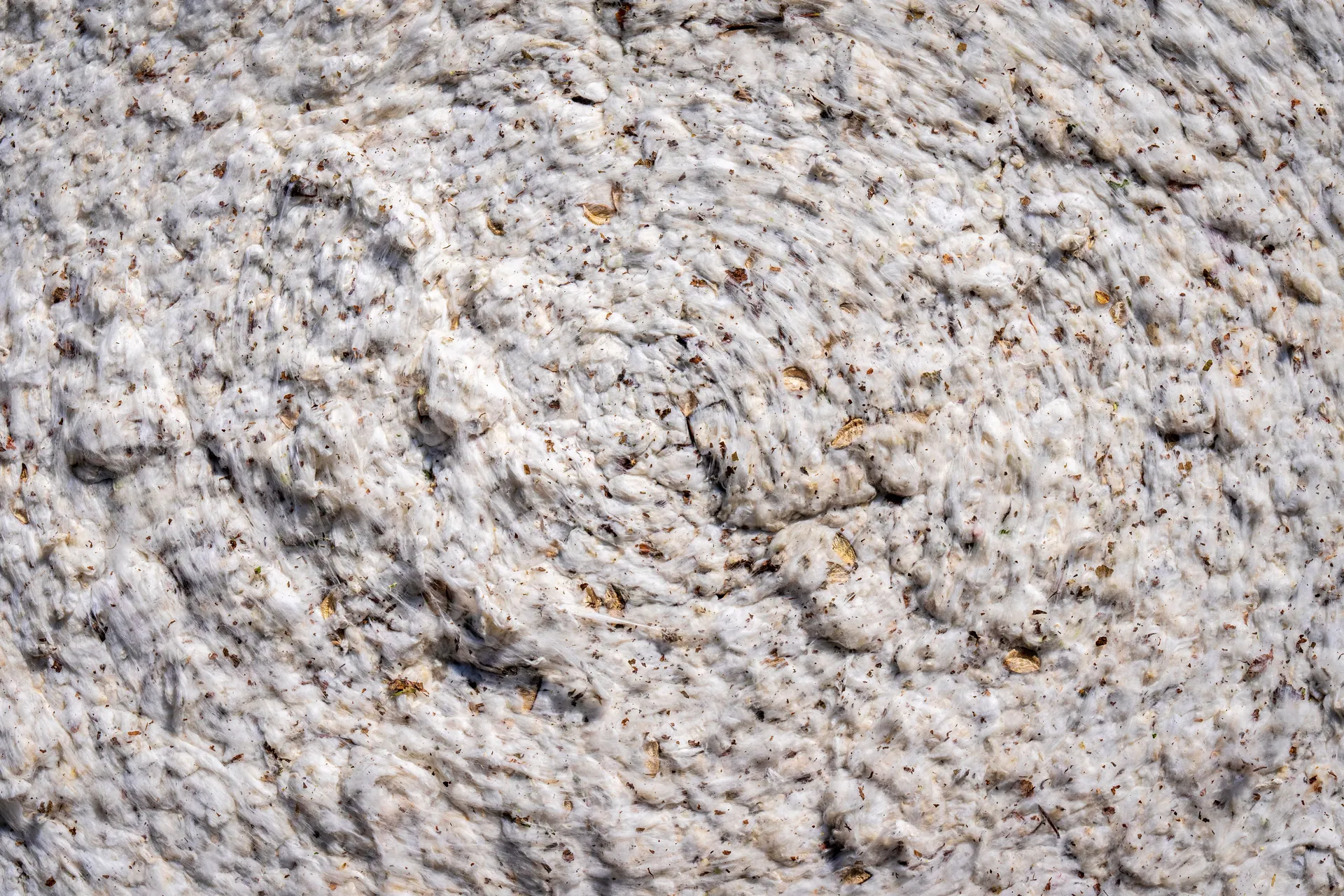Close-up of a swirled fabric texture, showcasing cotton in an abstract pattern.