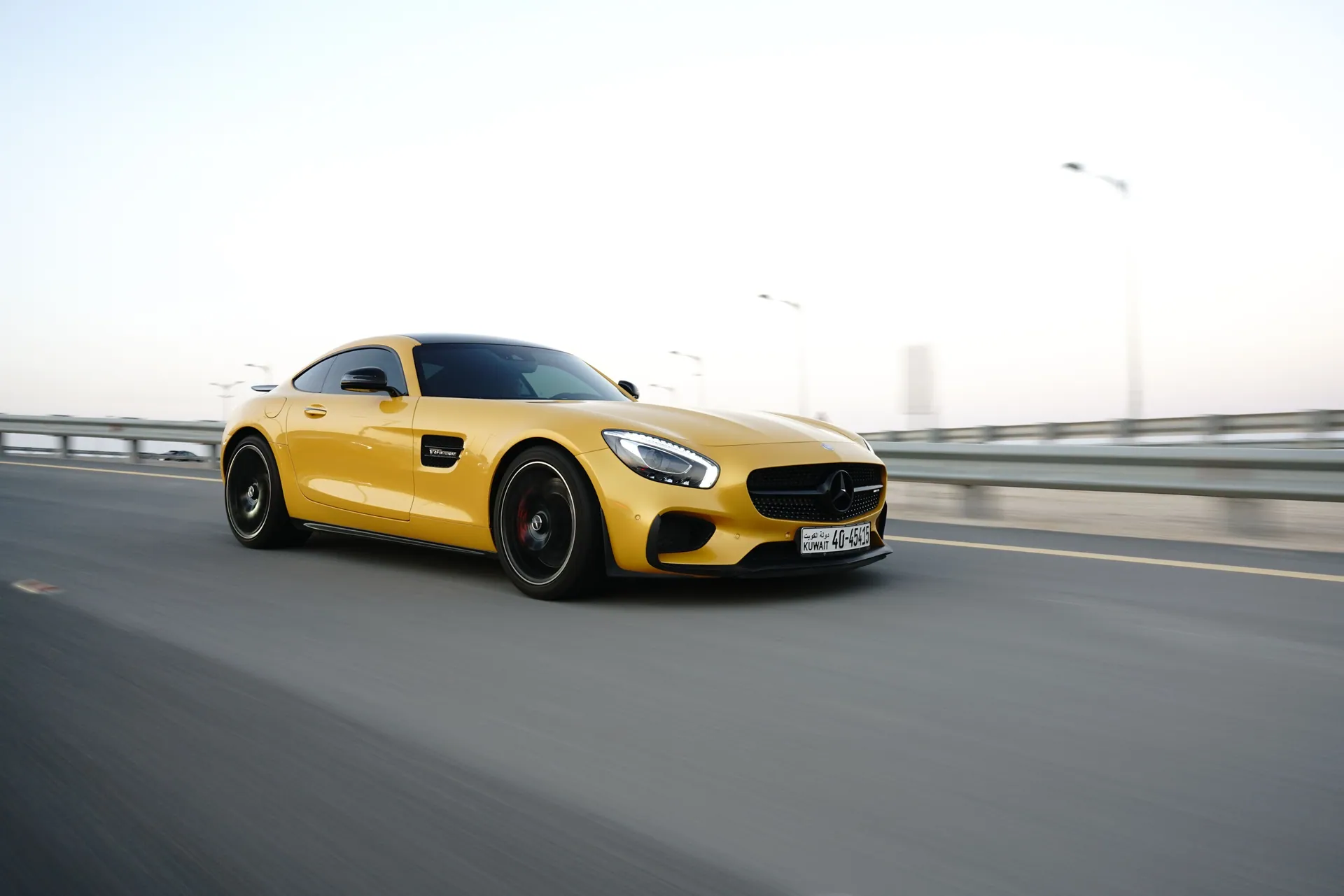 Luxury yellow sports car driving on highway at dusk, showcasing speed and elegance.