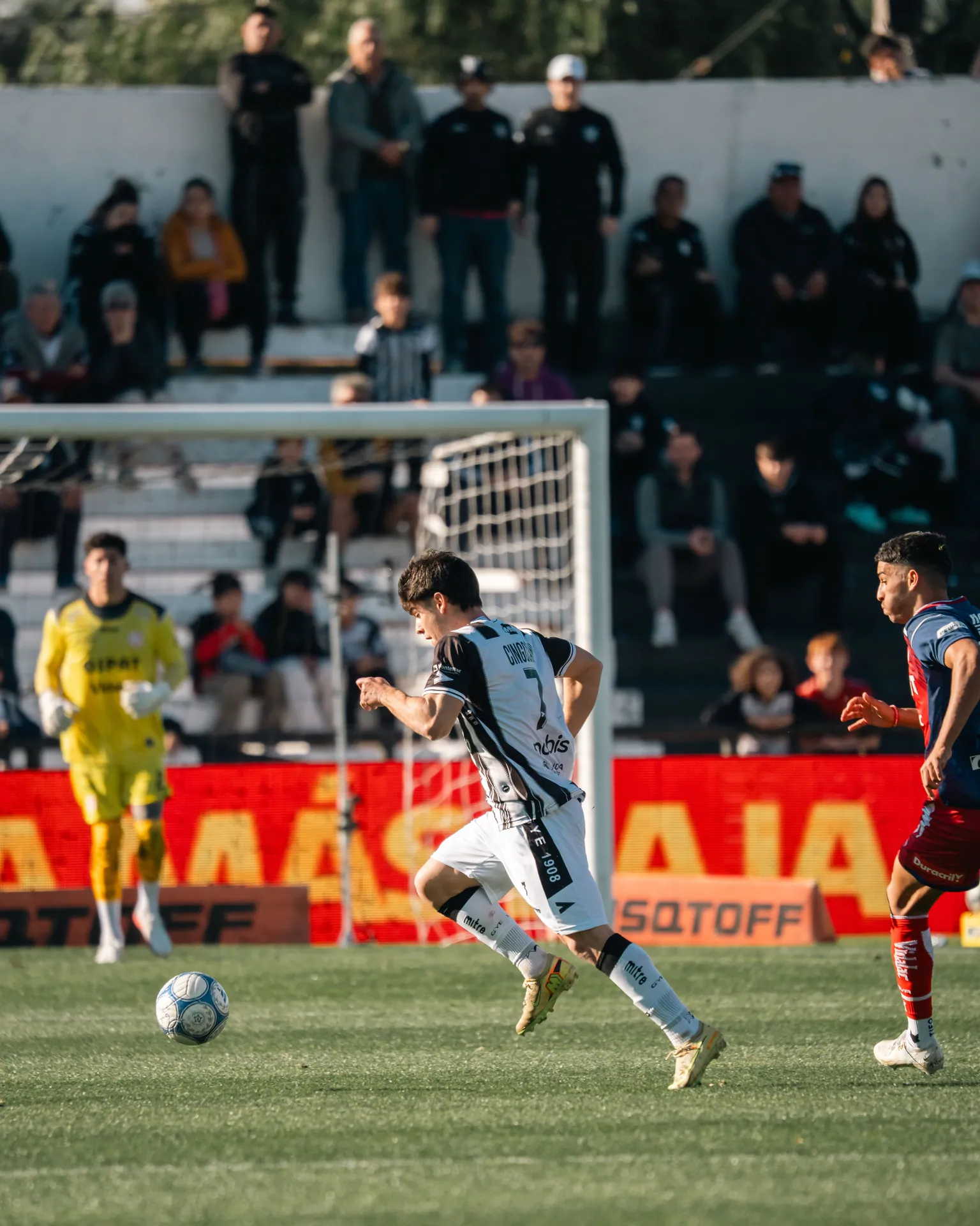 Action-packed soccer match with players in motion and spectator background.