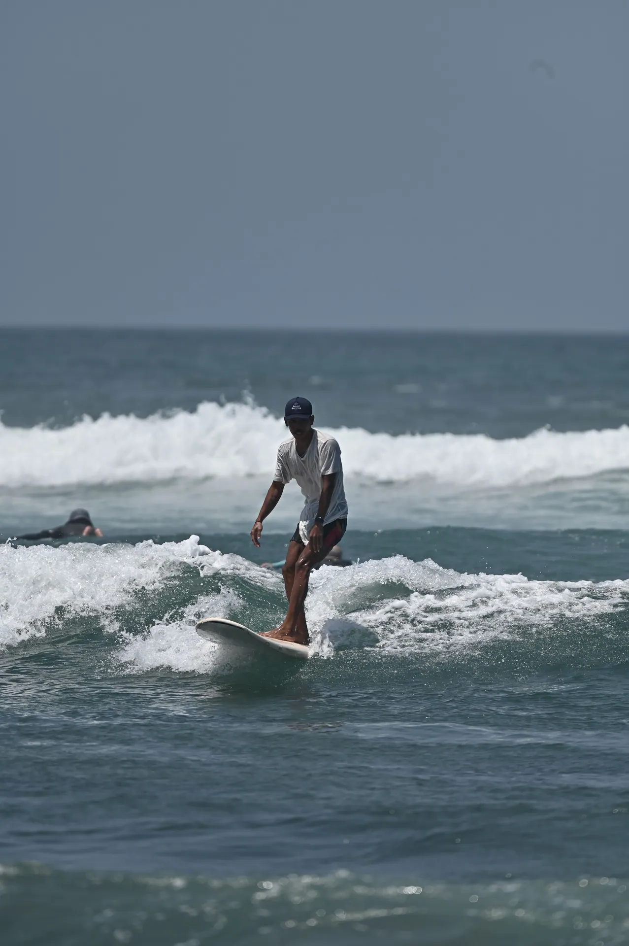 Surfer catching waves on a sunny day in Bali, Indonesia.