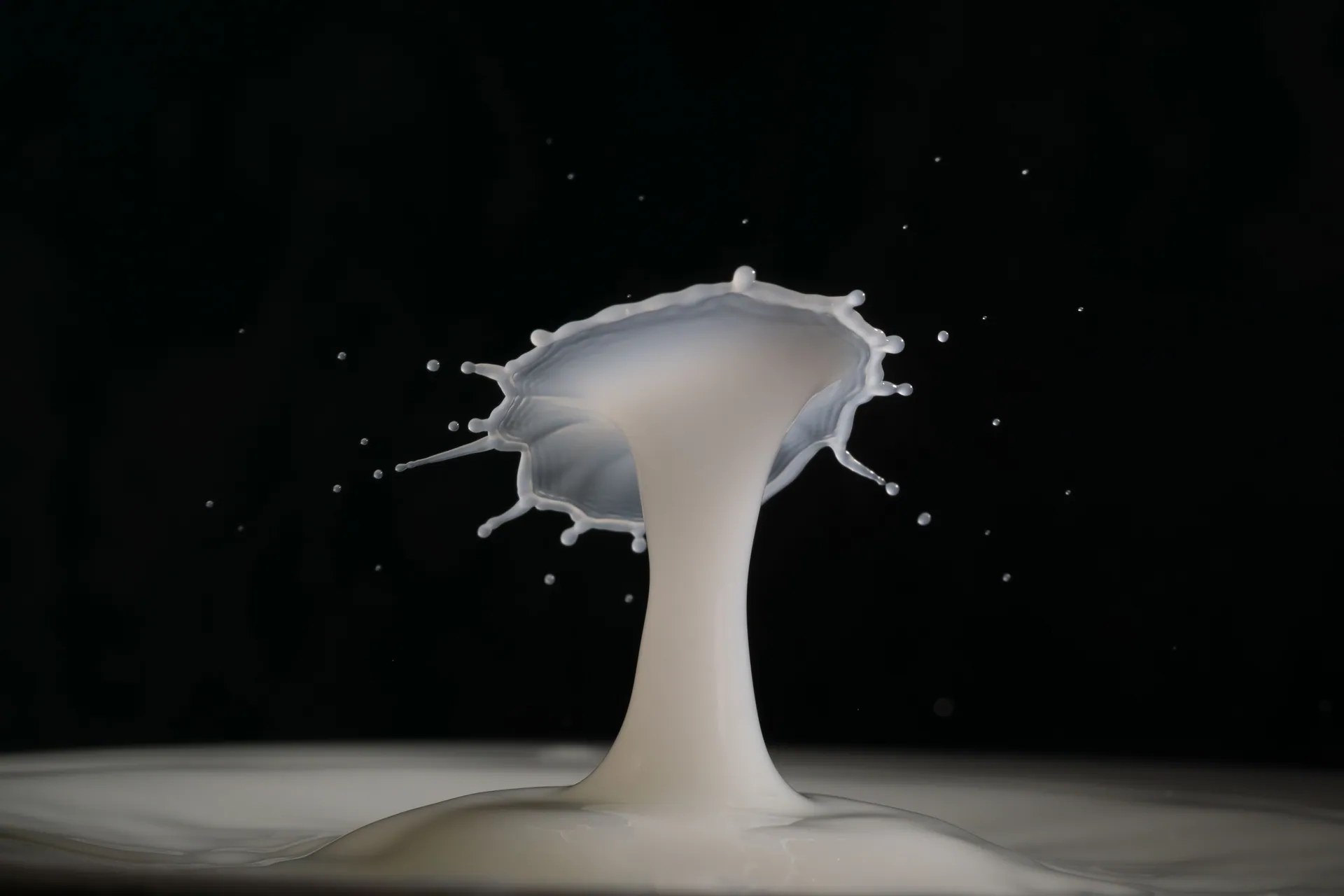 Captivating close-up of milk splash in motion, creating an artistic pattern against a dark backdrop.