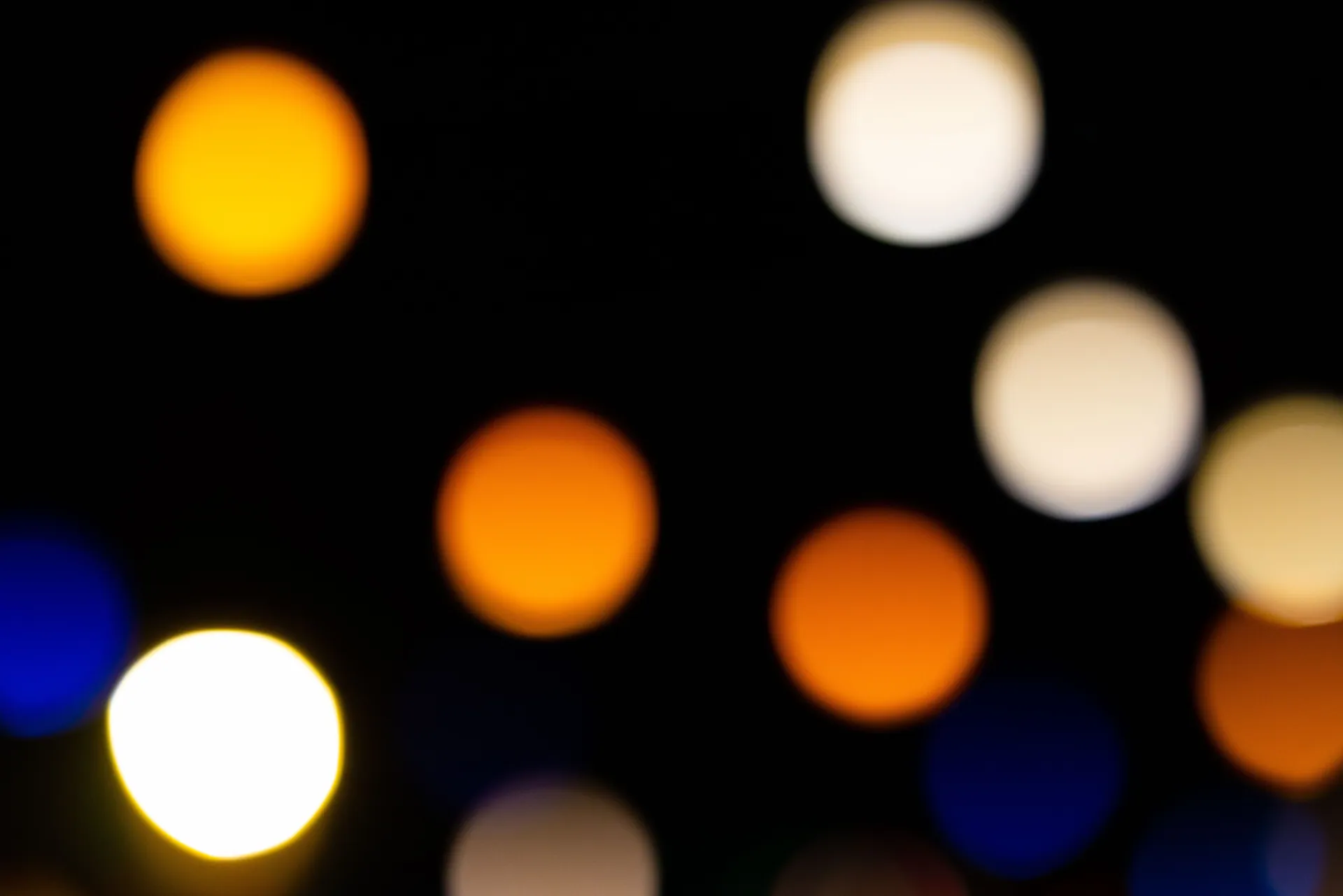 Colorful out-of-focus light circles creating a vibrant bokeh pattern against a dark backdrop.