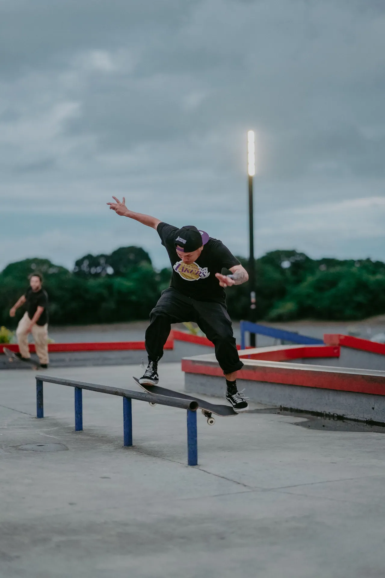 Action shot of a skateboarder executing a trick on a rail at an outdoor skate park.