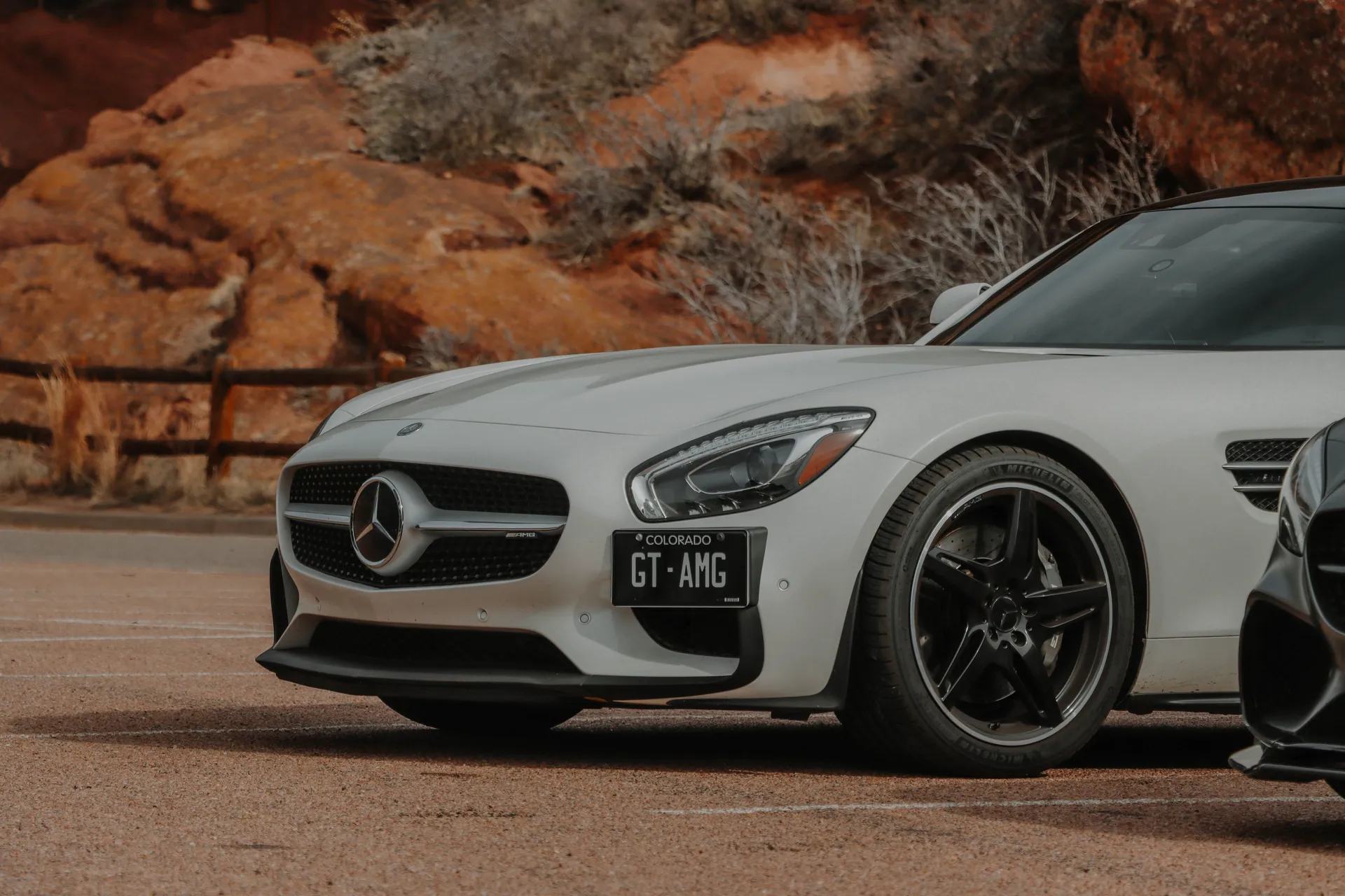 White Mercedes AMG GT parked against a rocky backdrop in Colorado. A fusion of luxury and nature.